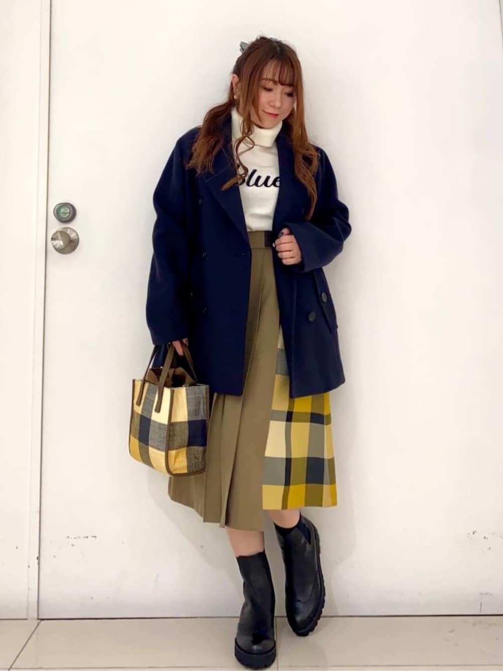 ブラック系のブーツ、ブルー系のピーコート、イエロー系のショルダーバッグを着用したレディースの秋コーディネートの4枚目の写真