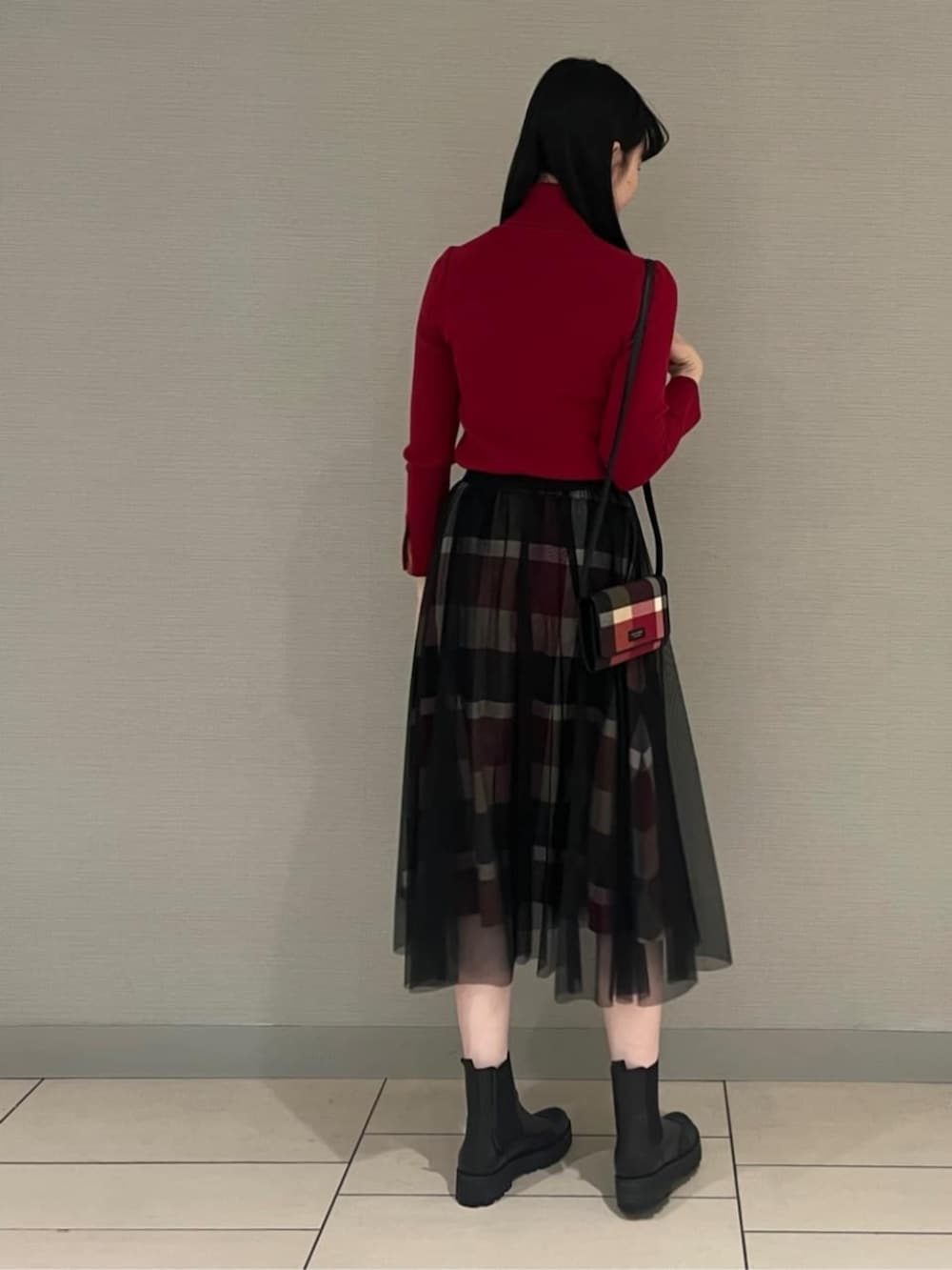 ブラック系のブーツ、レッド系のスカート、レッド系のニット/セーターを着用したレディースの秋コーディネートの4枚目の写真