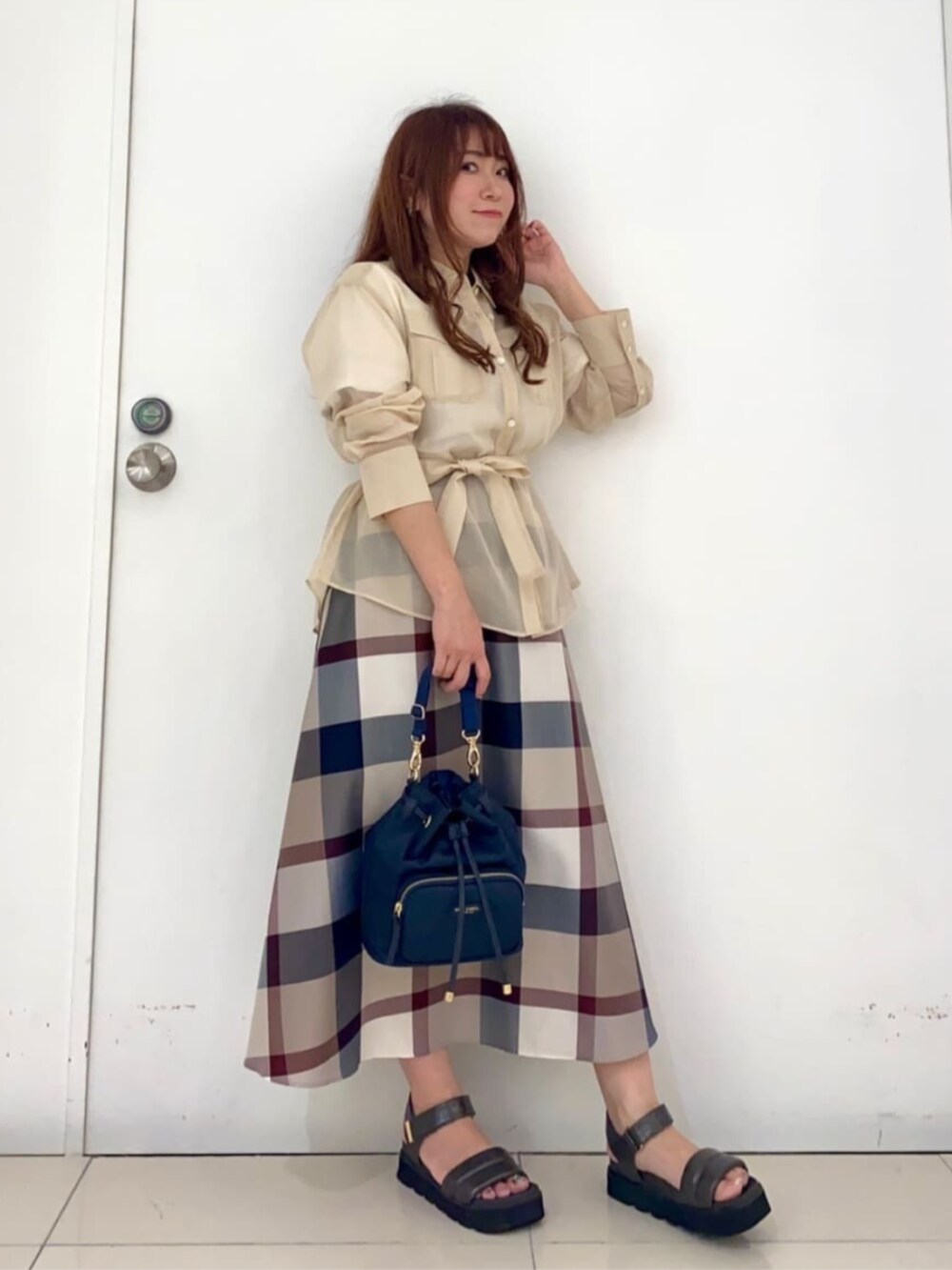 ベージュ系のスカート、ホワイト系のシャツ/ブラウス、ブルー系のショルダーバッグを着用したレディースの秋コーディネートの3枚目の写真