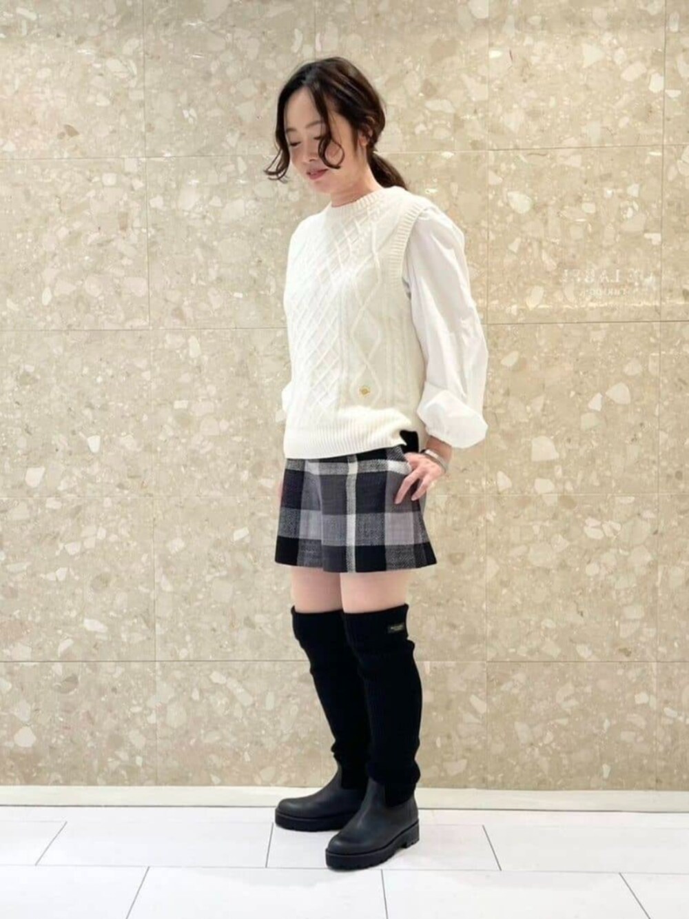 ホワイト系のニット/セーター、ブラック系のブーツ、ブラック系のその他パンツを着用したレディースの秋コーディネートの3枚目の写真