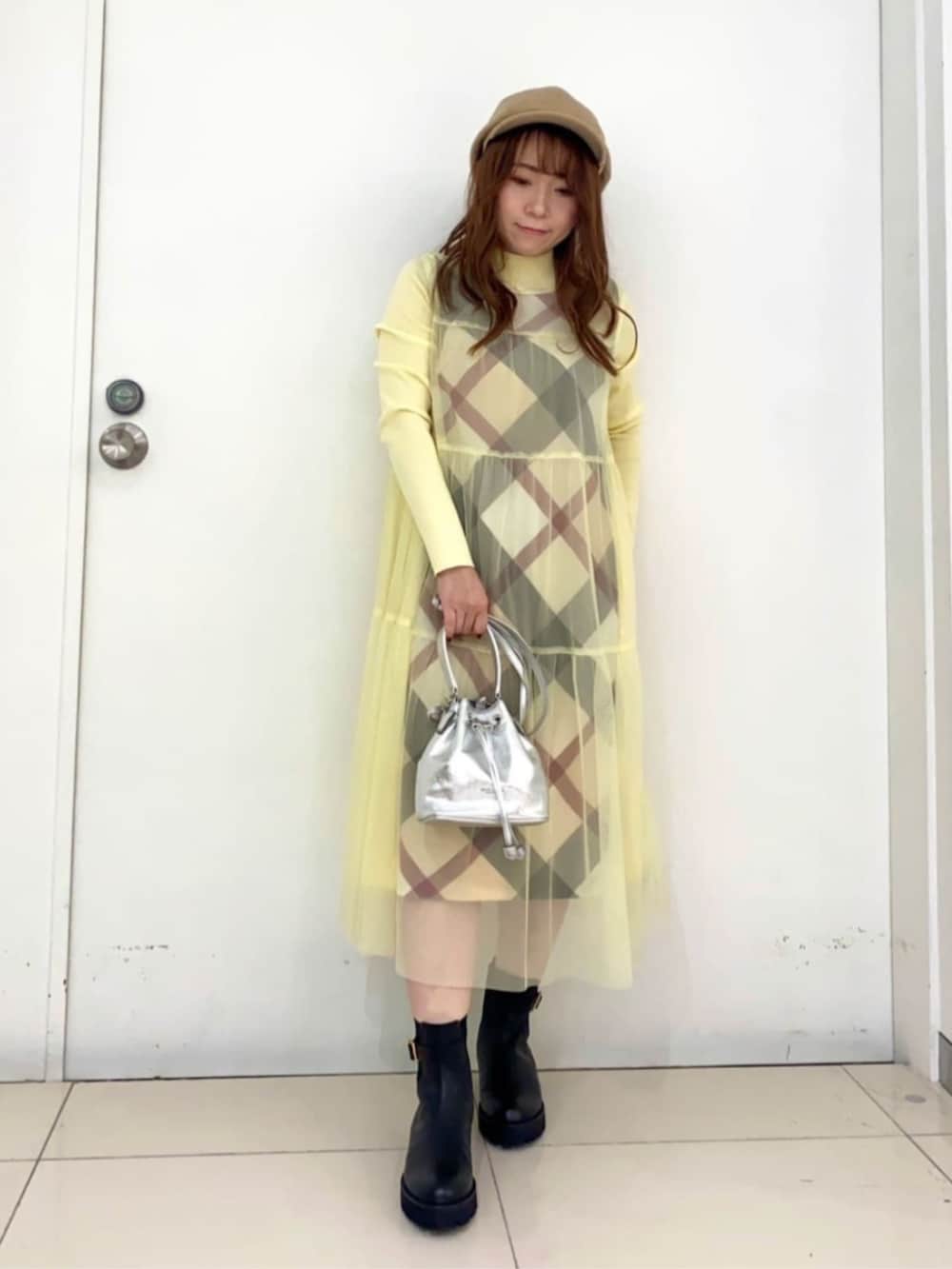 ブラック系のブーツ、イエロー系のワンピース、シルバー系のショルダーバッグを着用したレディースの夏コーディネートの3枚目の写真