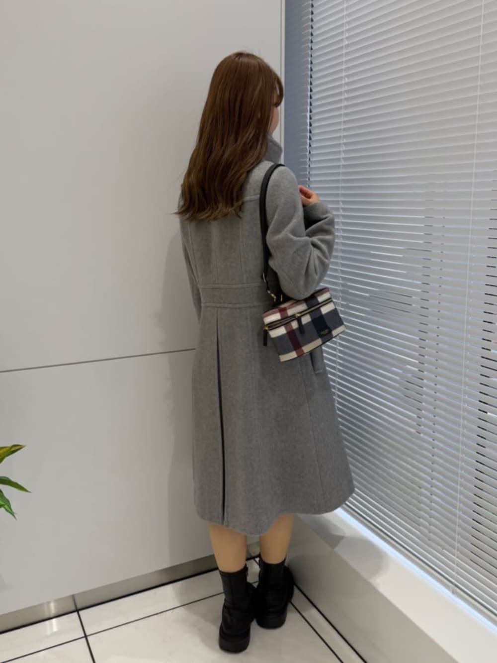 ベージュ系のショルダーバッグ、グレー系のその他アウターを着用したレディースの冬コーディネートの3枚目の写真