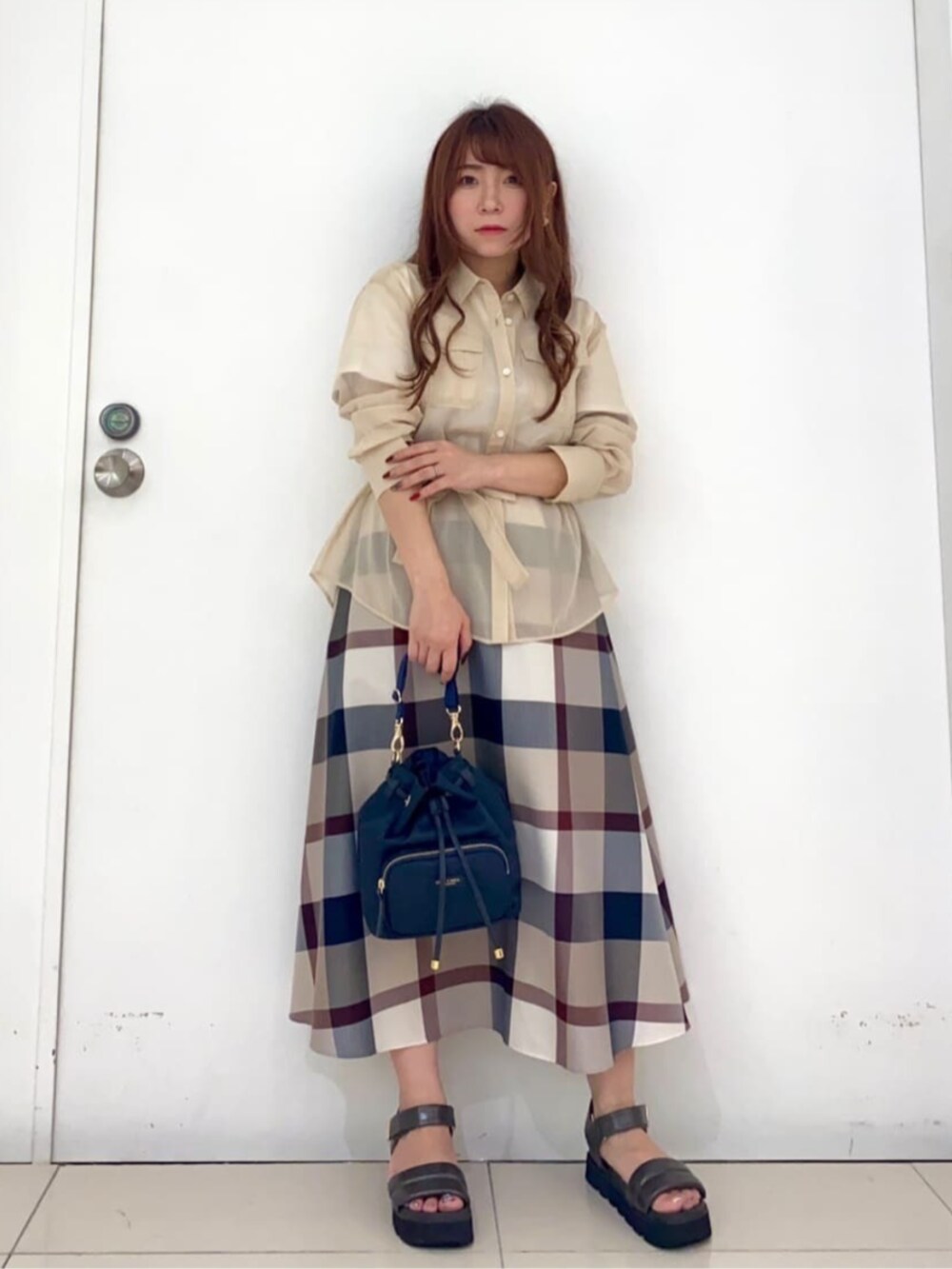 ベージュ系のスカート、ホワイト系のシャツ/ブラウス、ブルー系のショルダーバッグを着用したレディースの秋コーディネートの2枚目の写真