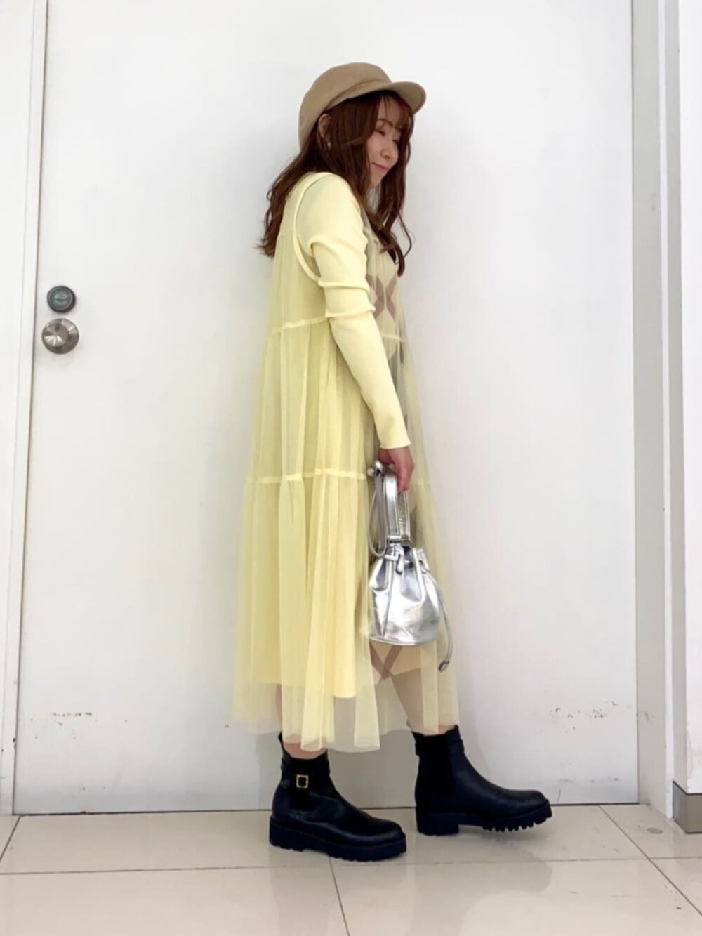 ブラック系のブーツ、イエロー系のワンピース、シルバー系のショルダーバッグを着用したレディースの夏コーディネートの4枚目の写真