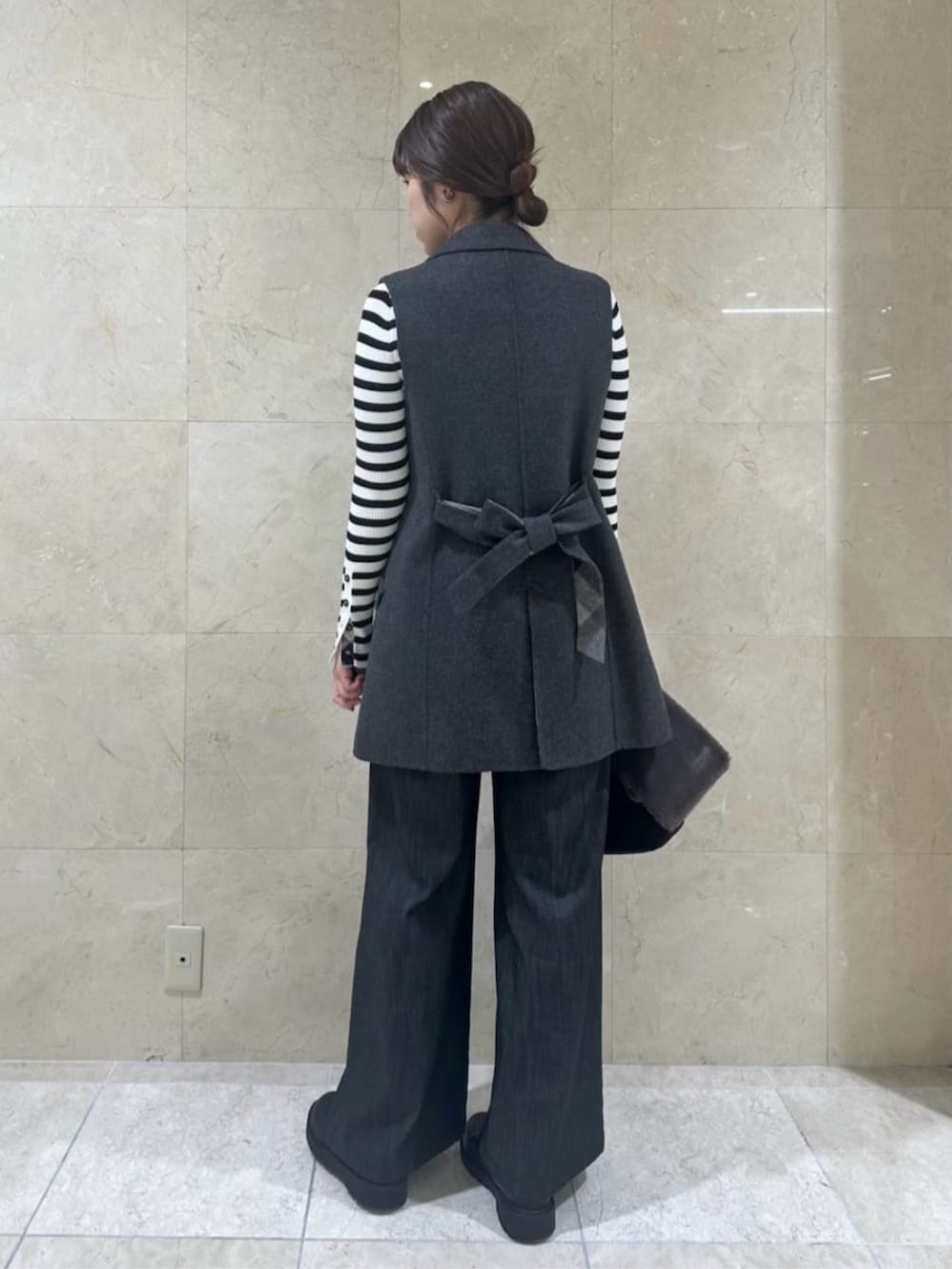 ブラック系のその他パンツ、ブラック系のハンドバッグ、グレー系のベストを着用したレディースの秋コーディネートの3枚目の写真