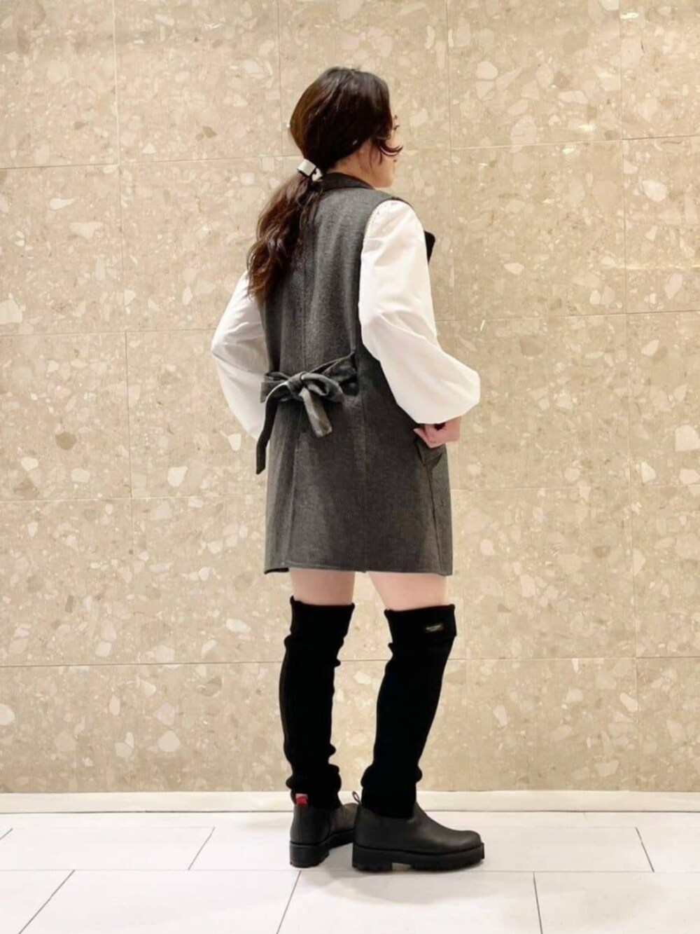 ホワイト系のニット/セーター、ブラック系のブーツ、ブラック系のその他パンツを着用したレディースの秋コーディネートの2枚目の写真