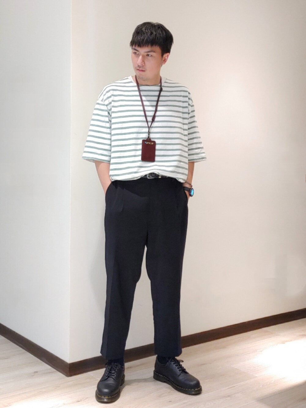 ブラック系のスラックス、ブラック系のドレスシューズ、グリーン系のTシャツ/カットソーを着用したメンズの春コーディネートの2枚目の写真