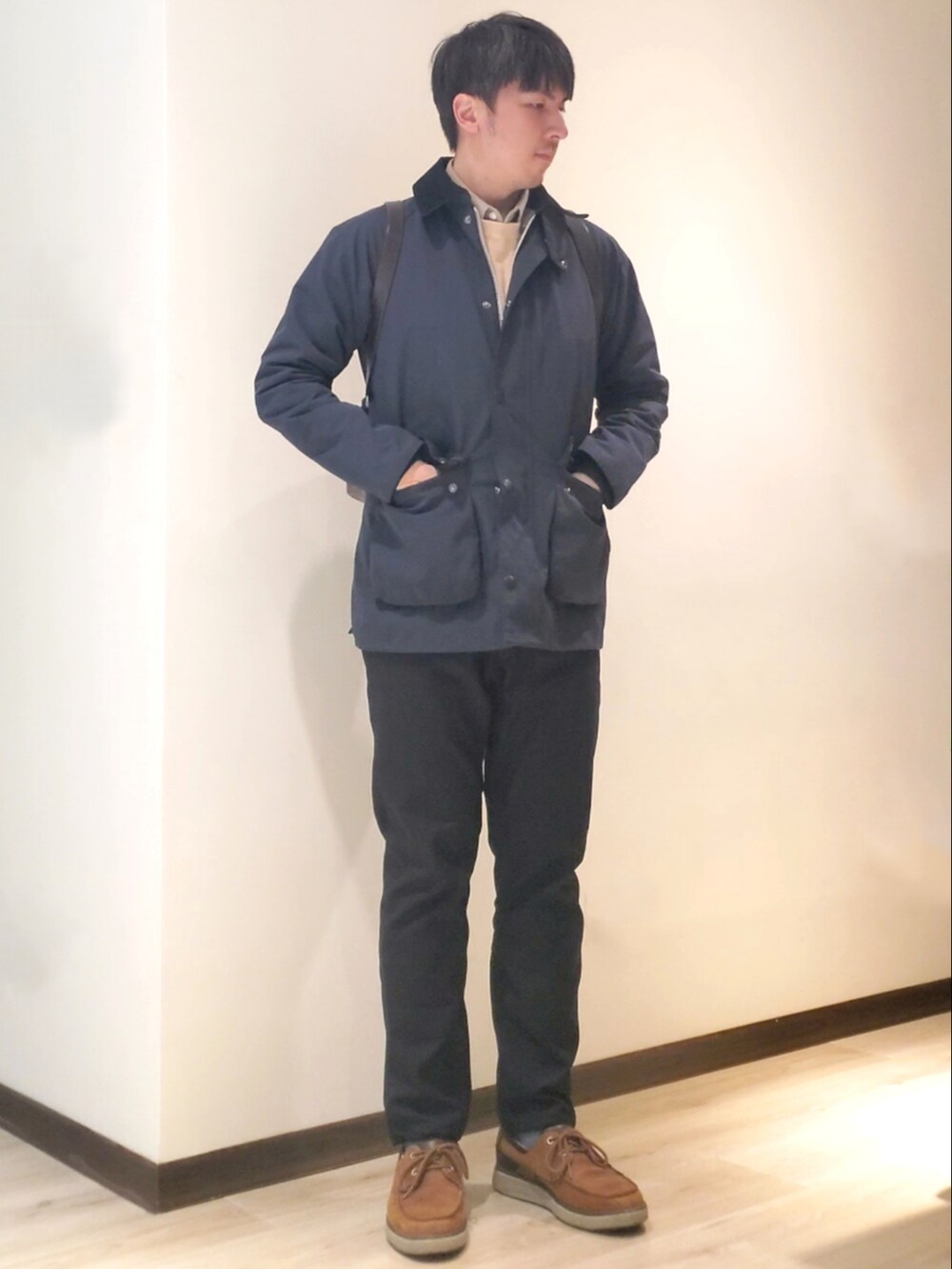 ブラック系のチノパンツ、ベージュ系のニット/セーター、ブラウン系のその他シューズを着用したメンズの冬コーディネートの2枚目の写真