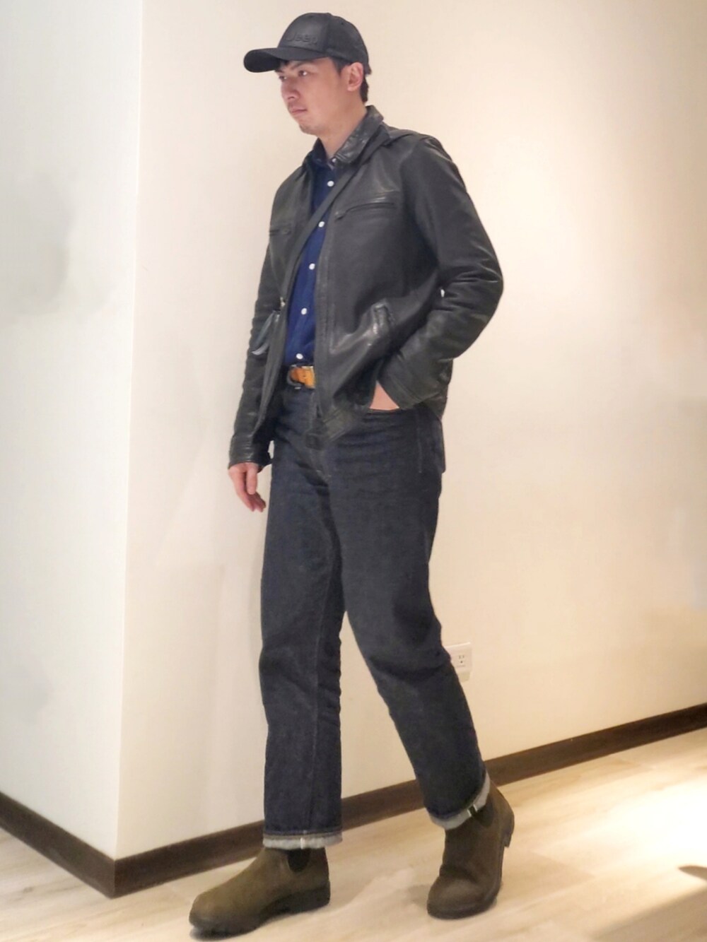 グリーン系のショルダーバッグ、グリーン系のブーツ、ブルー系のデニムパンツを着用したメンズの冬コーディネートの2枚目の写真