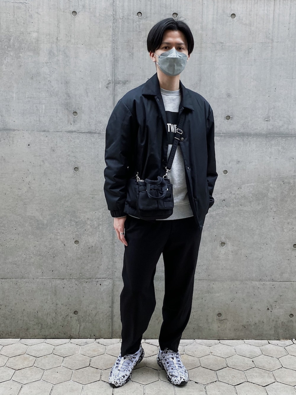 グレー系のスウェット、ブラック系のブルゾン、ブラック系のショルダーバッグを着用したメンズの春コーディネートの2枚目の写真