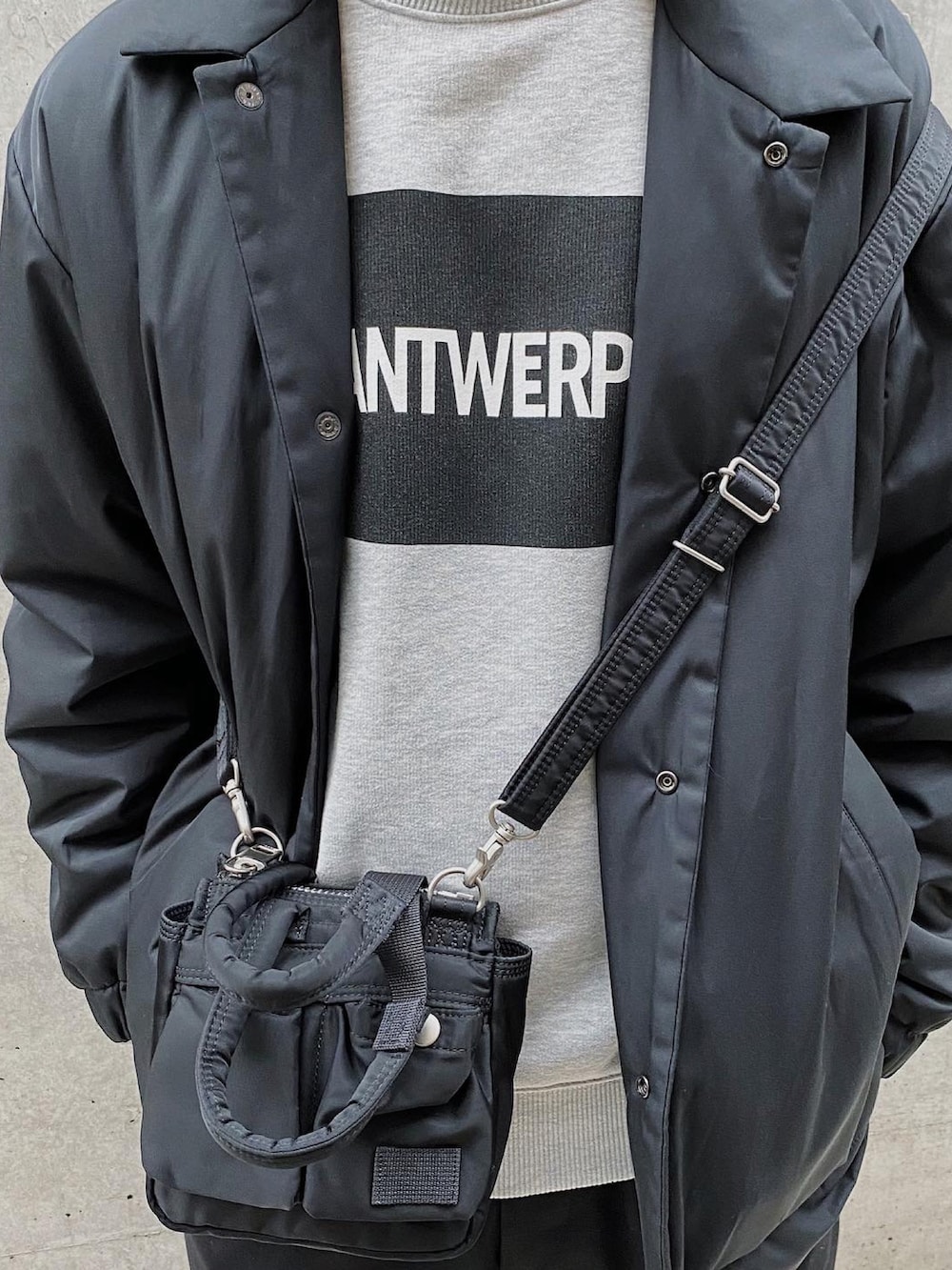 グレー系のスウェット、ブラック系のブルゾン、ブラック系のショルダーバッグを着用したメンズの春コーディネートの3枚目の写真