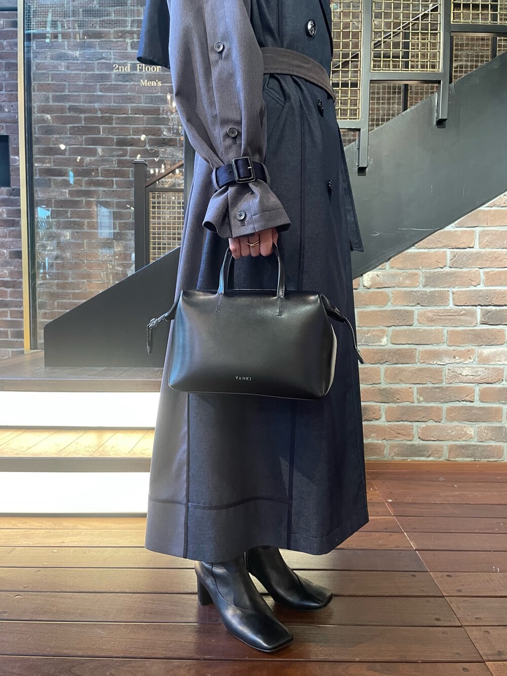 ブルー系のトレンチコートを着用したレディースの秋コーディネートの4枚目の写真