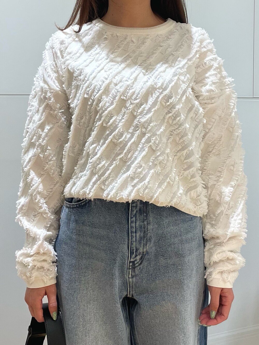 ブルー系のデニムパンツ、ホワイト系のTシャツ/カットソーを着用したレディースの冬コーディネートの2枚目の写真