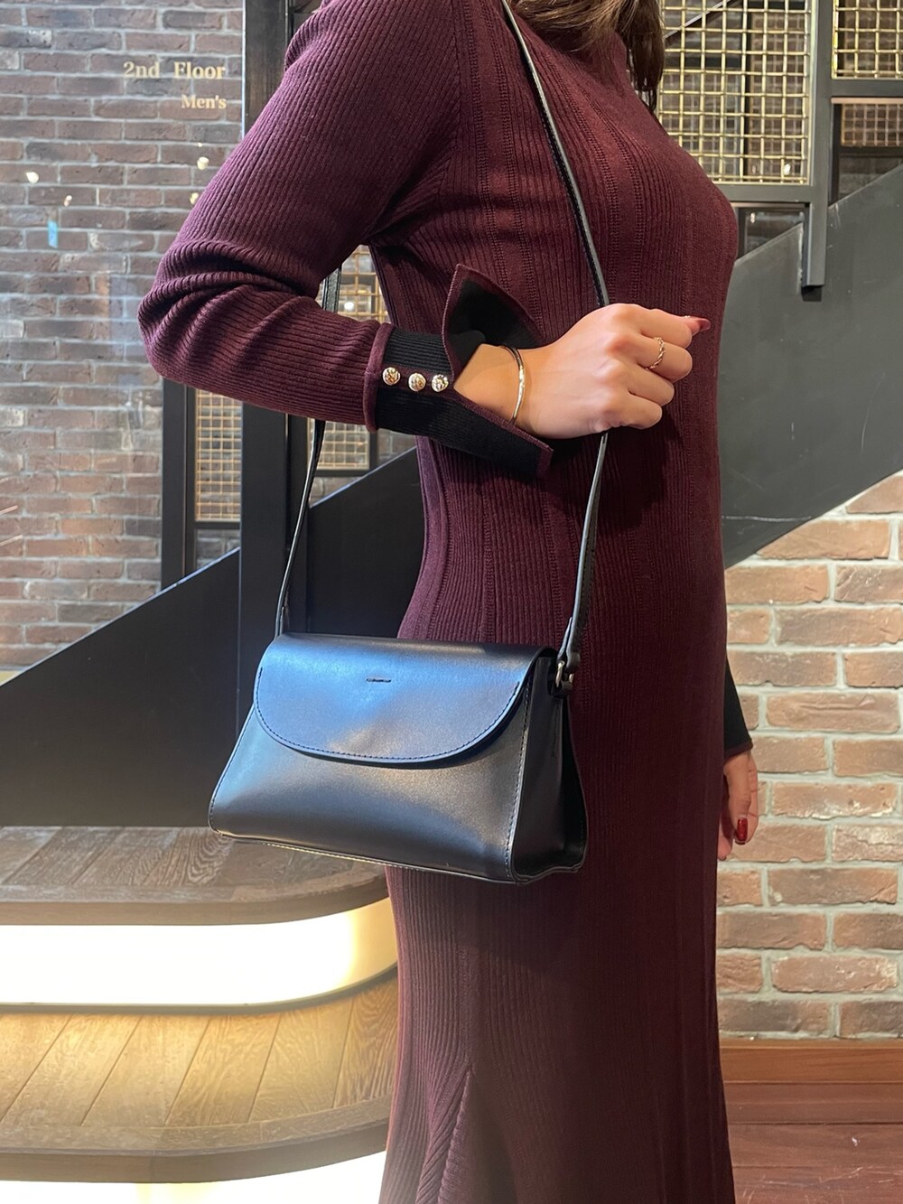 ブラウン系のベスト、レッド系のワンピースを着用したレディースの冬コーディネートの4枚目の写真