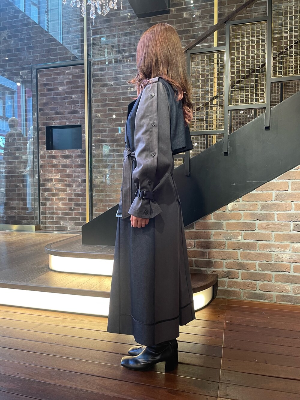 ブルー系のトレンチコートを着用したレディースの秋コーディネートの2枚目の写真