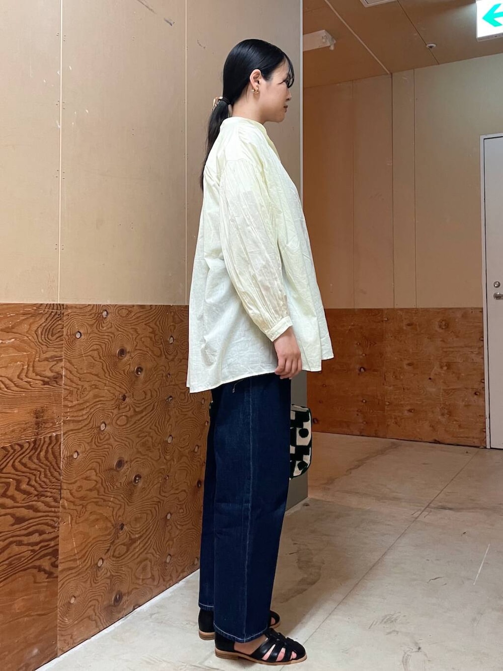 ブラック系のサンダル、ブルー系のデニムパンツ、イエロー系のシャツ/ブラウスを着用したレディースの春コーディネートの3枚目の写真