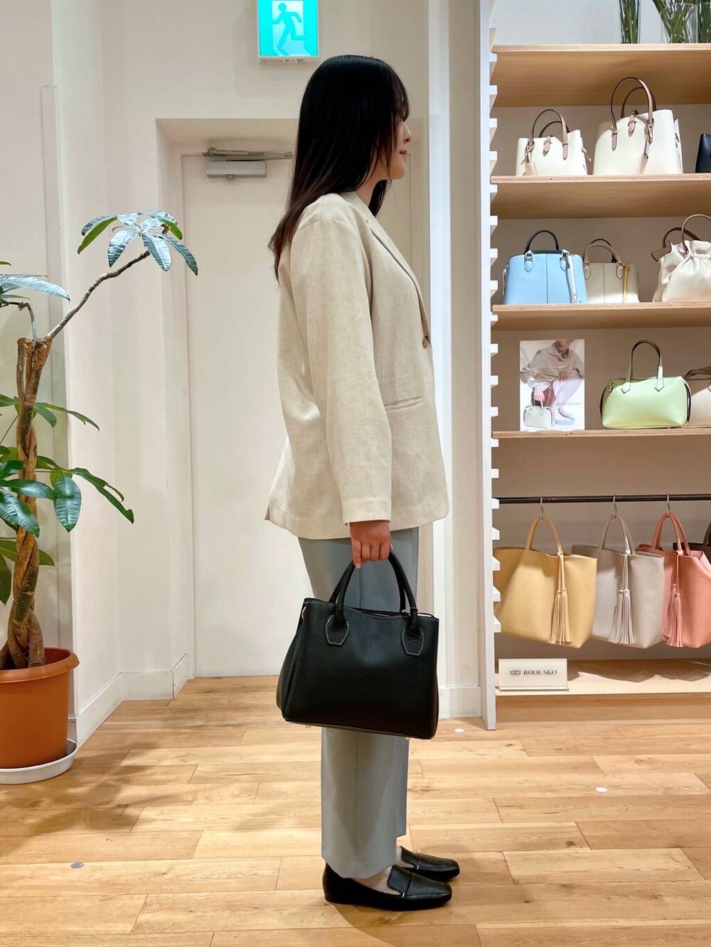 ブラック系のローファー、ブラック系のショルダーバッグ、ブルー系のその他パンツを着用したレディースの春コーディネートの2枚目の写真