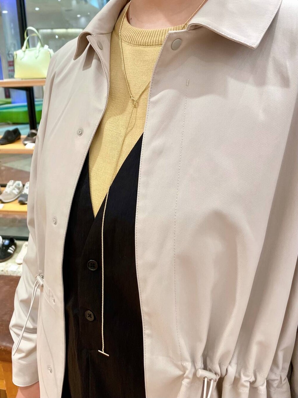 ブラック系のブーツ、イエロー系のニット/セーター、ブラック系のジャンパースカートを着用したレディースの春コーディネートの5枚目の写真