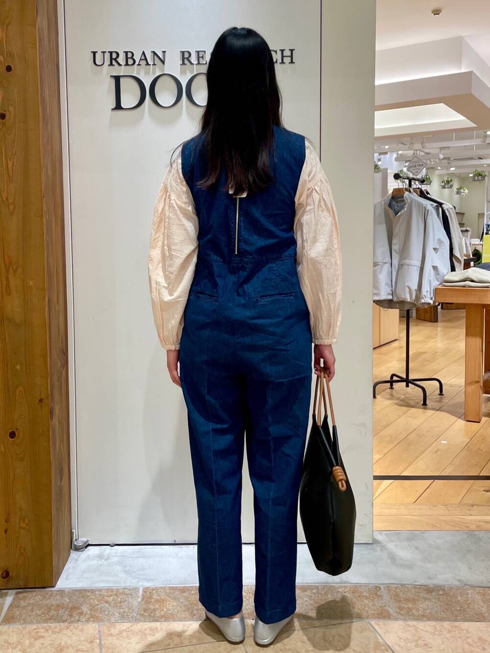 シルバー系のパンプス、ブラック系のトートバッグ、ブルー系のサロペット/オーバーオールを着用したレディースの春コーディネートの3枚目の写真