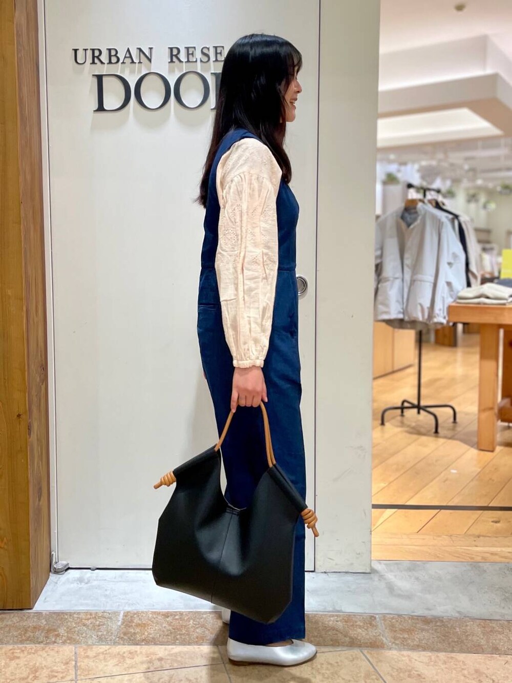 シルバー系のパンプス、ブラック系のトートバッグ、ブルー系のサロペット/オーバーオールを着用したレディースの春コーディネートの2枚目の写真