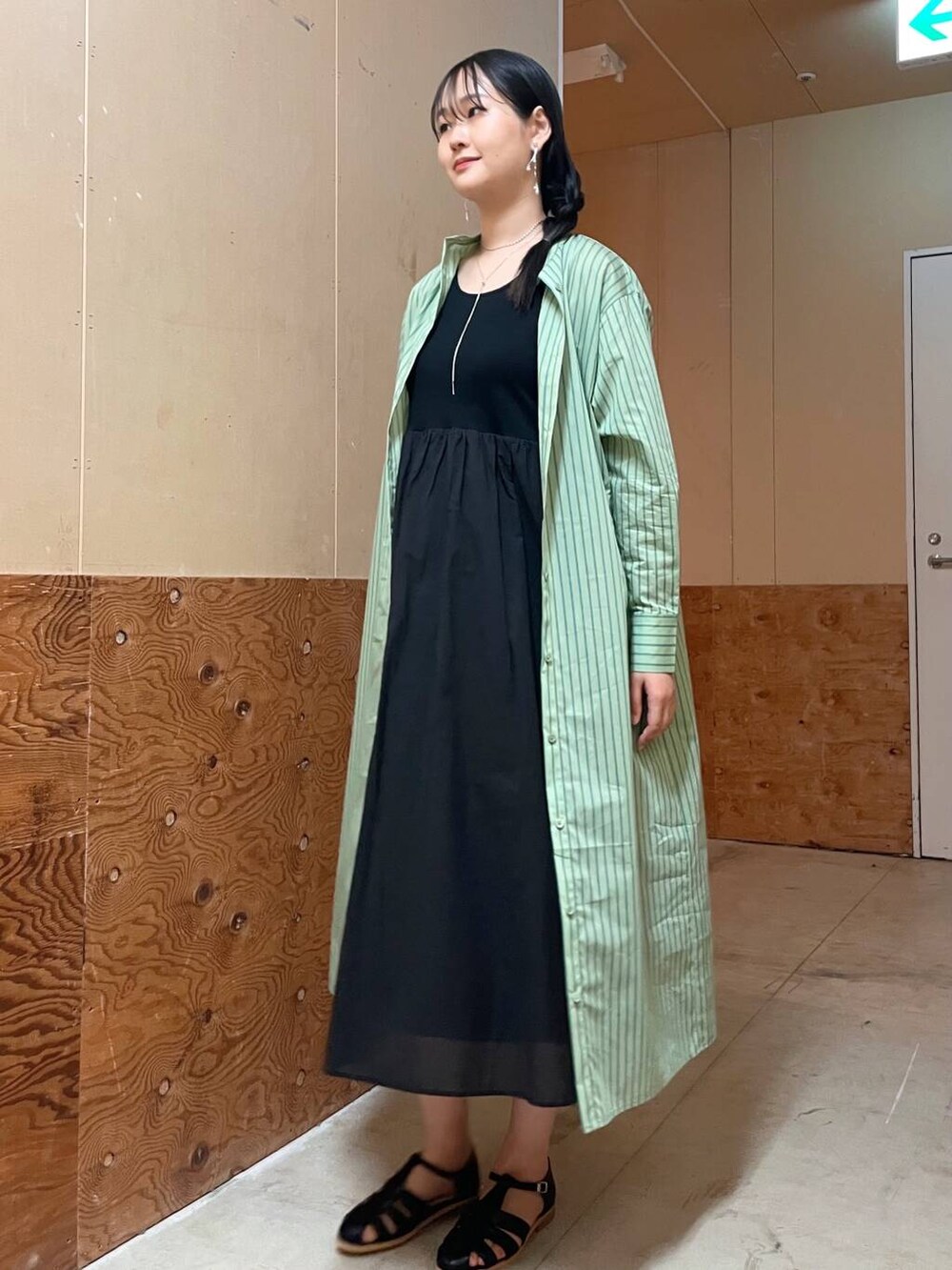 ベージュ系のハンドバッグ、ブラック系のサンダル、グリーン系のワンピースを着用したレディースの春コーディネートの6枚目の写真