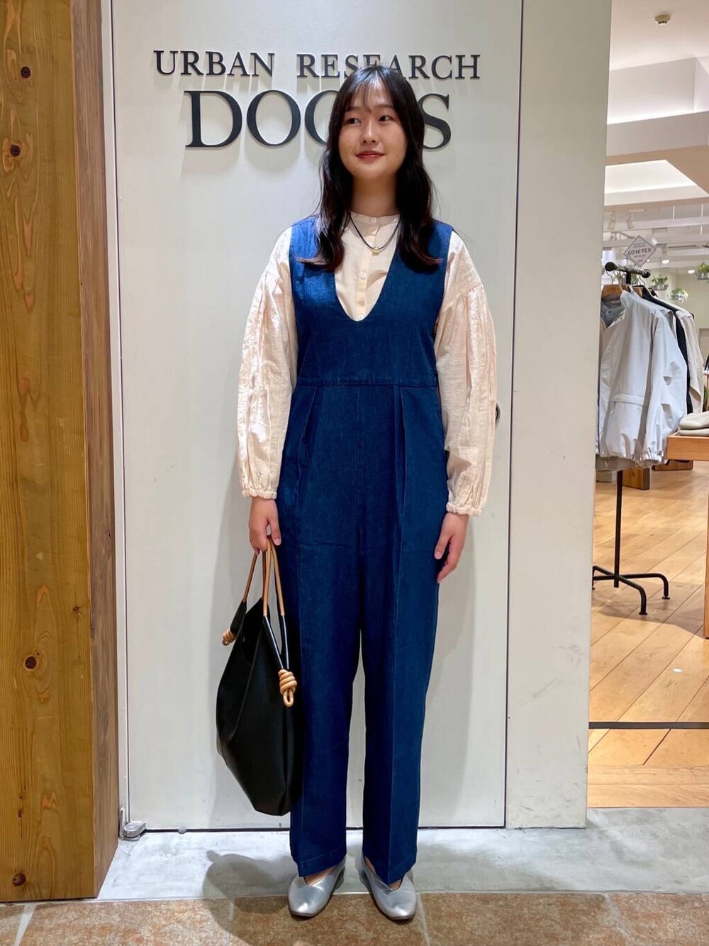 シルバー系のパンプス、ブラック系のトートバッグ、ブルー系のサロペット/オーバーオールを着用したレディースの春コーディネートの8枚目の写真