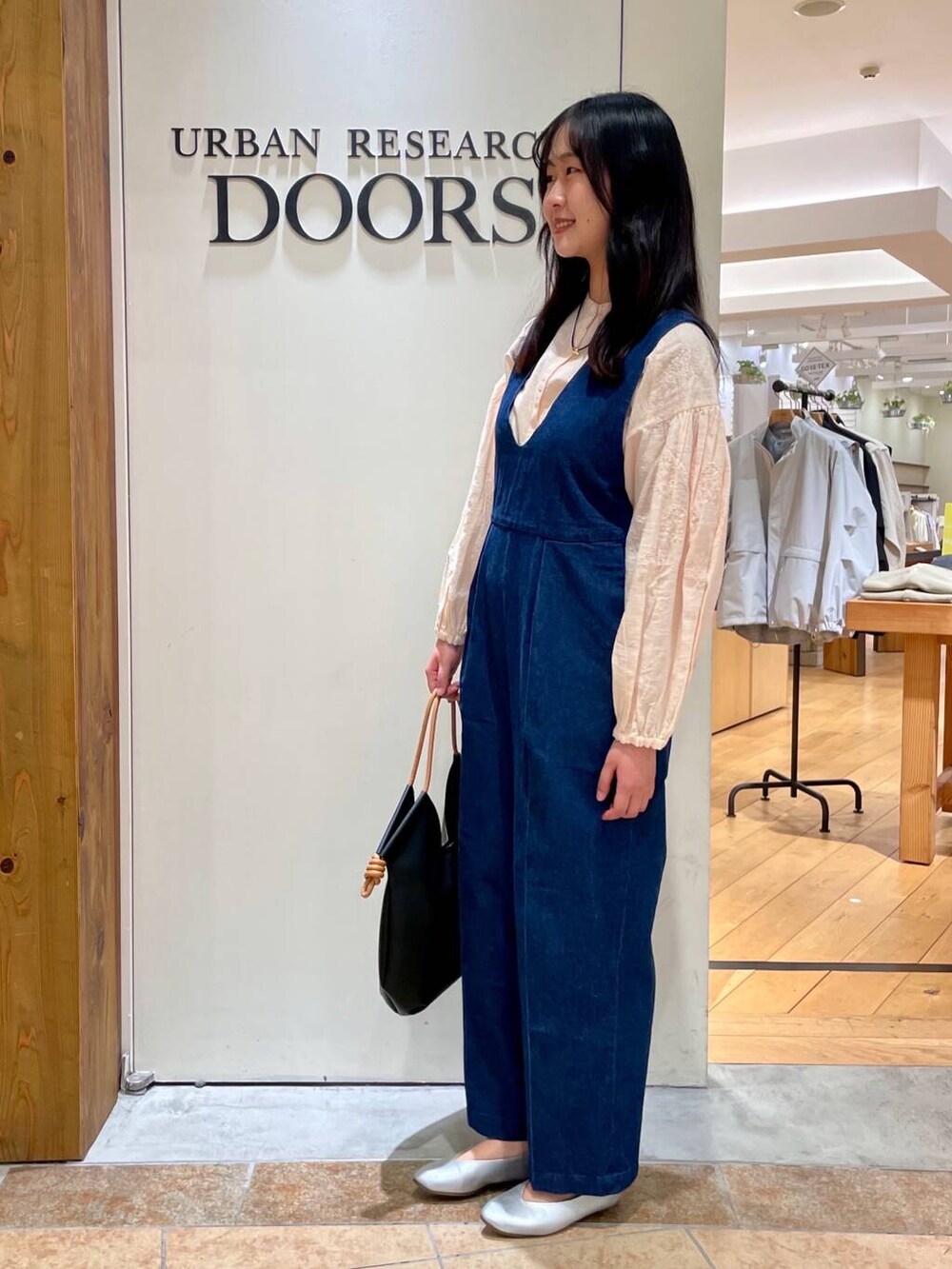 シルバー系のパンプス、ブラック系のトートバッグ、ブルー系のサロペット/オーバーオールを着用したレディースの春コーディネートの4枚目の写真