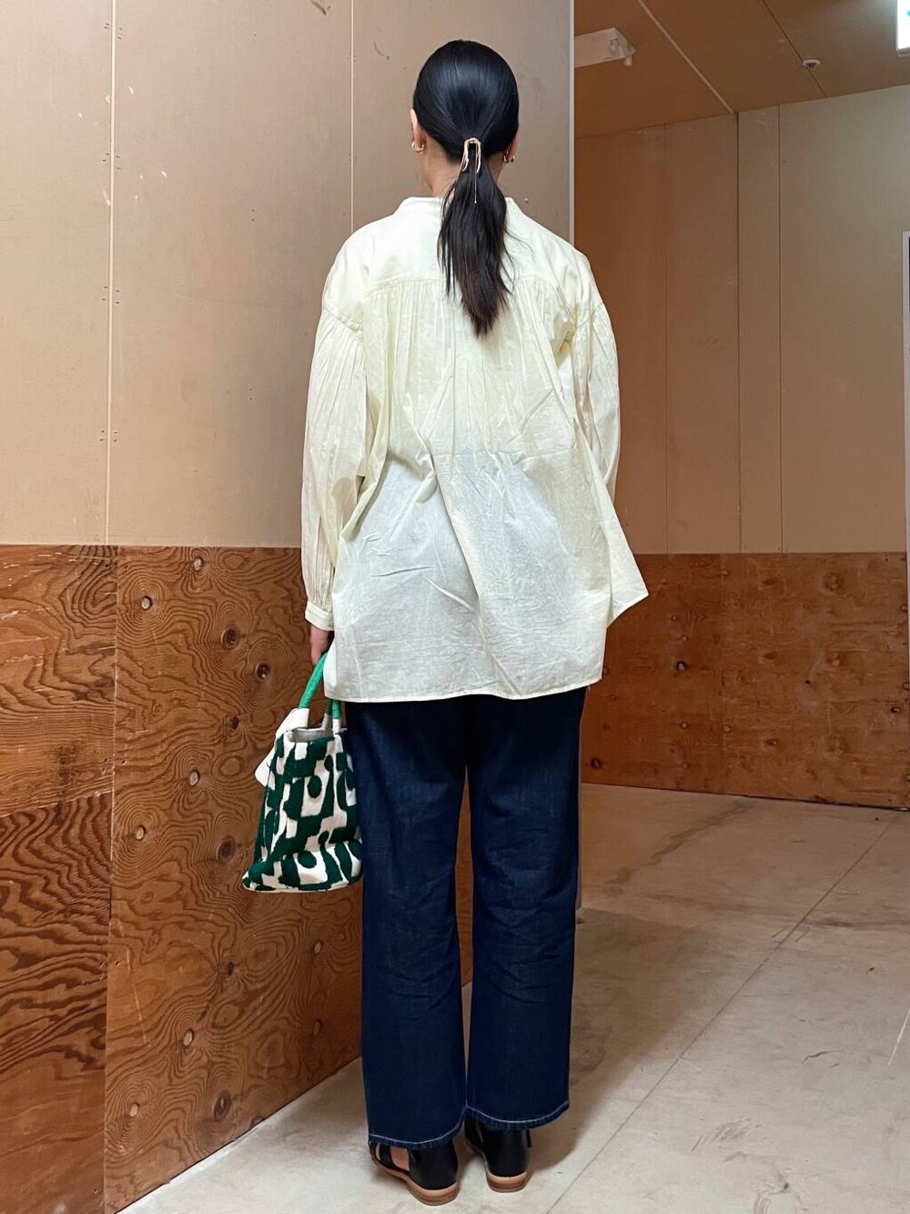 ブラック系のサンダル、ブルー系のデニムパンツ、イエロー系のシャツ/ブラウスを着用したレディースの春コーディネートの4枚目の写真