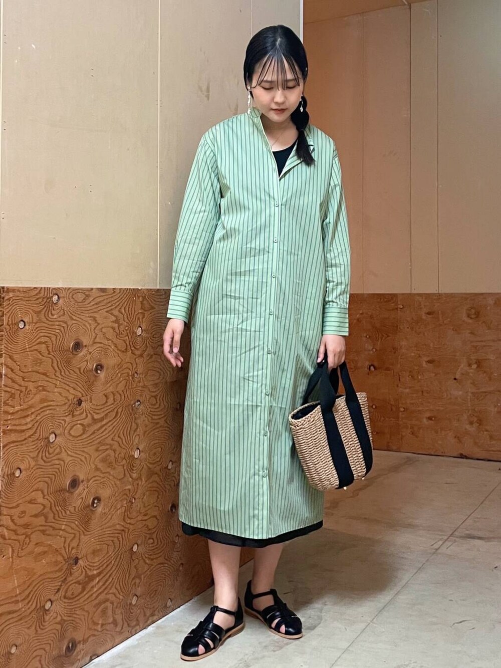 ベージュ系のハンドバッグ、ブラック系のサンダル、グリーン系のワンピースを着用したレディースの春コーディネートの5枚目の写真