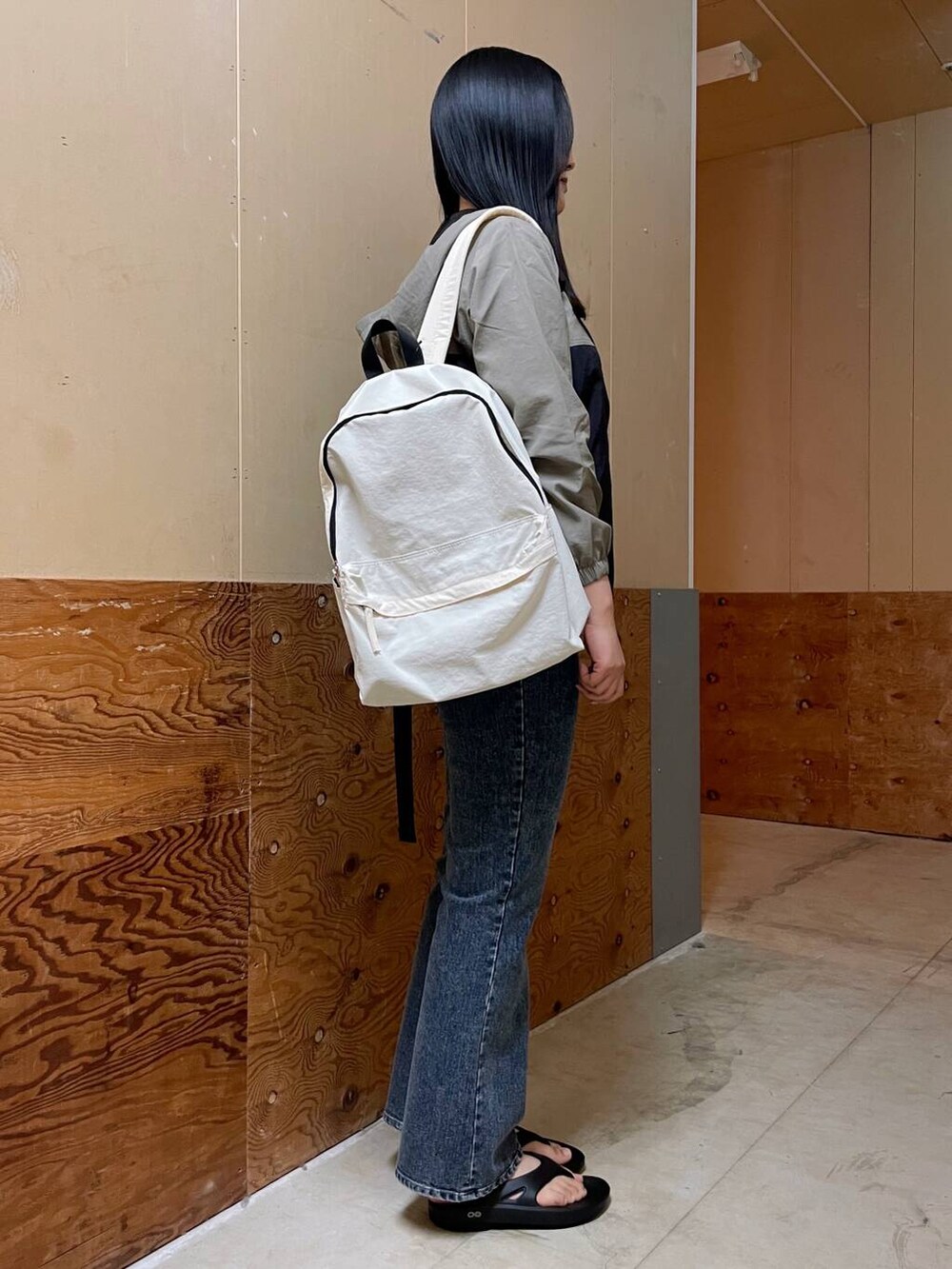 ホワイト系のバックパック/リュック、ブルー系のデニムパンツ、ブラウン系のTシャツ/カットソーを着用したレディースの春コーディネートの2枚目の写真