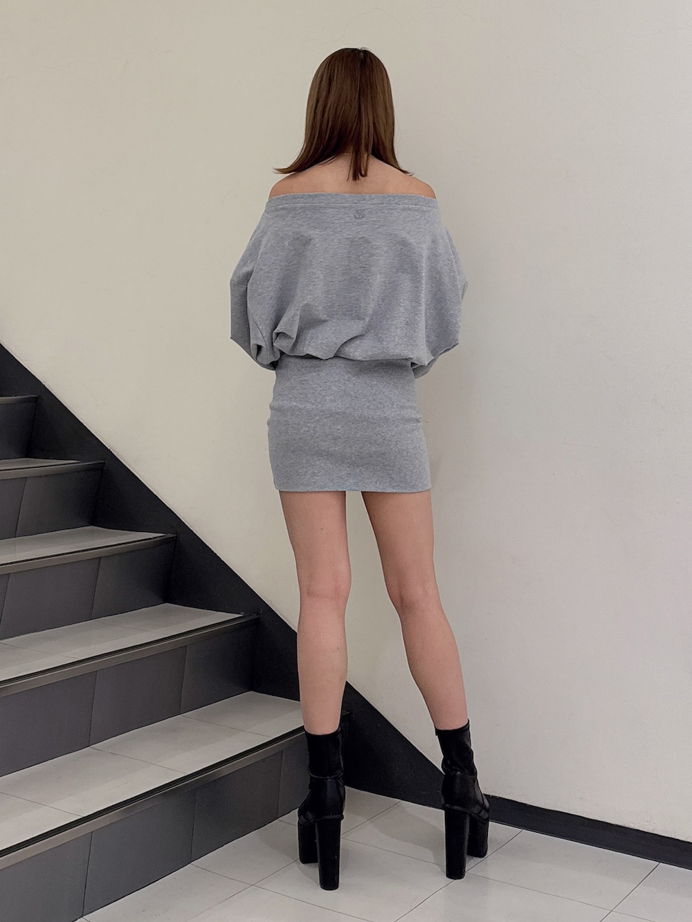 グレー系のワンピース、ブラック系のブーツを着用したレディースの冬コーディネートの3枚目の写真