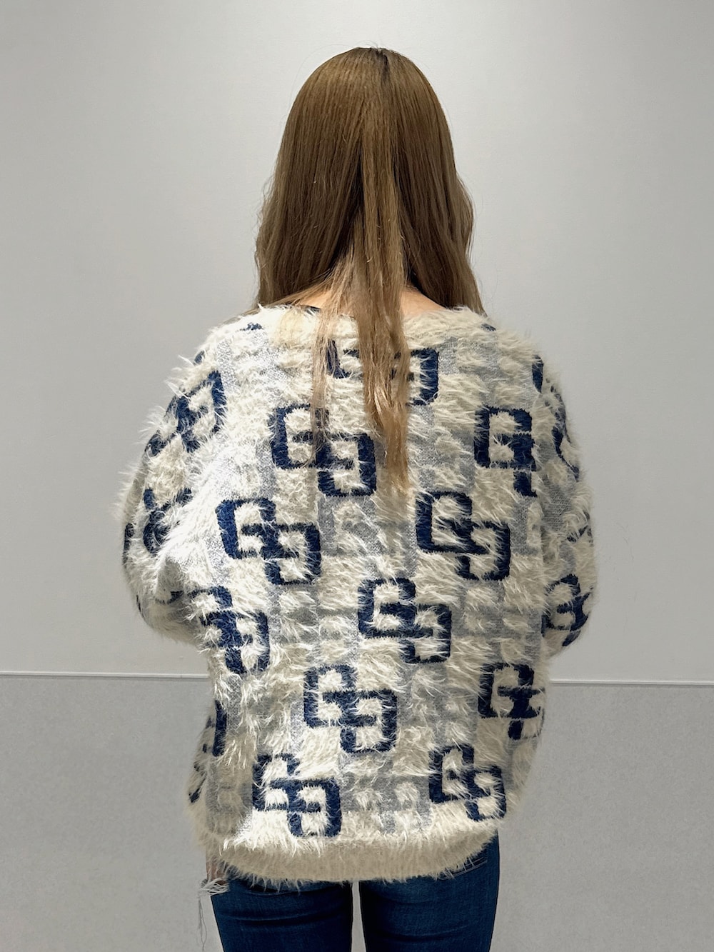 ホワイト系のニット/セーター、ブルー系のデニムパンツ、ブラック系のブーツを着用したレディースの冬コーディネートの5枚目の写真