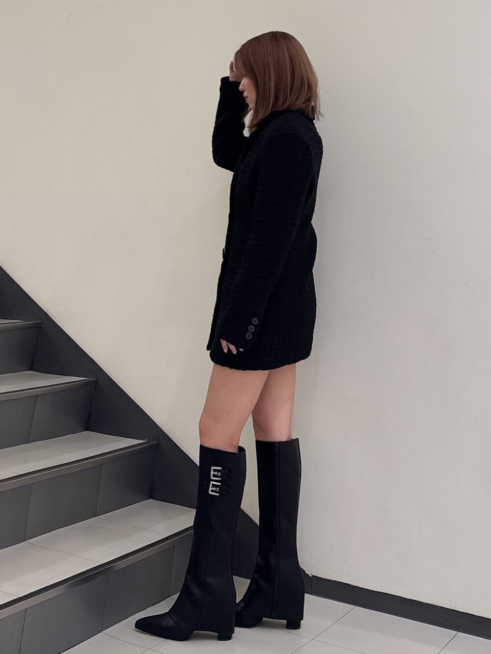 ブラック系のテーラードジャケット、ブラック系のブーツを着用したレディースの秋コーディネートの2枚目の写真