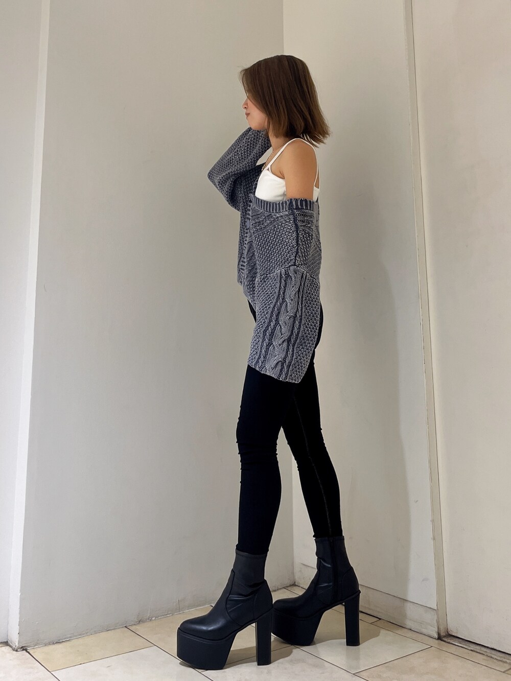 ブルー系のニット/セーター、ホワイト系のキャミソール、ブラック系のデニムパンツを着用したレディースの秋コーディネートの2枚目の写真