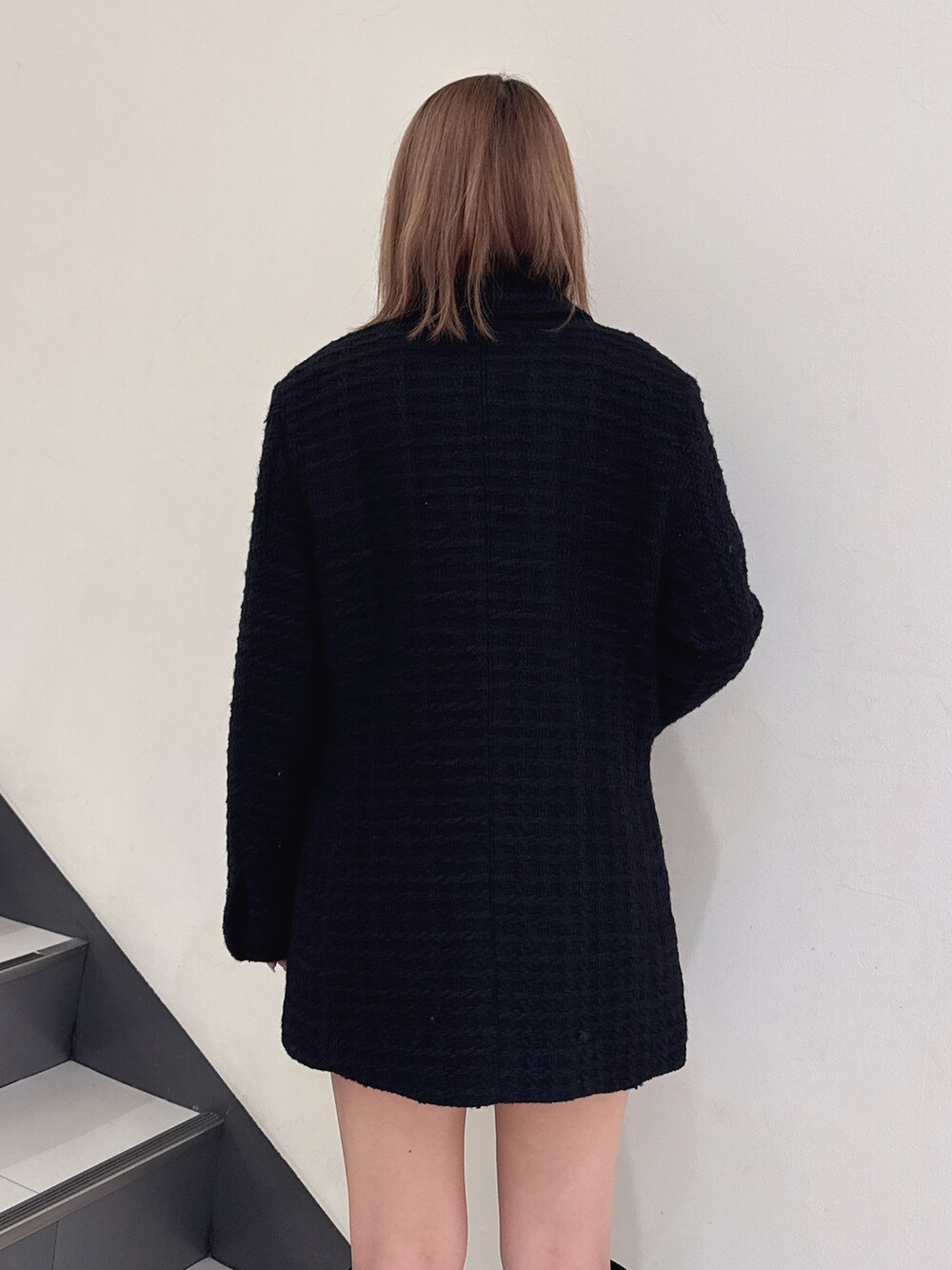 ブラック系のテーラードジャケット、ブラック系のブーツを着用したレディースの秋コーディネートの5枚目の写真