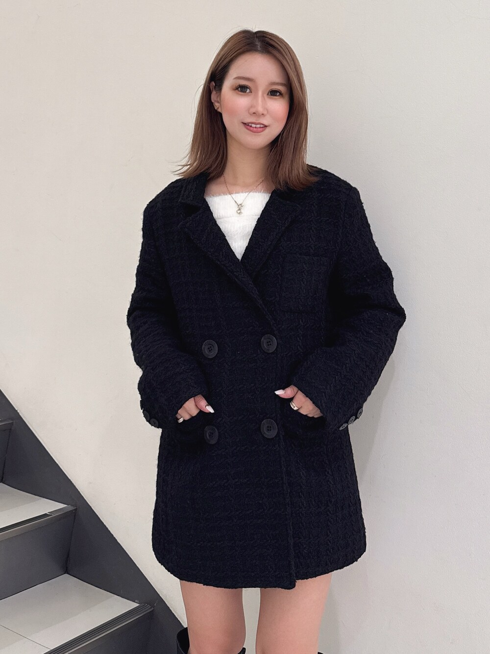 ブラック系のテーラードジャケット、ブラック系のブーツを着用したレディースの秋コーディネートの4枚目の写真