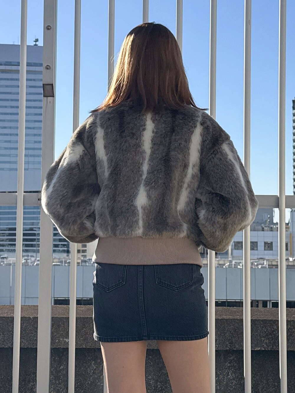 その他のその他アウター、ホワイト系のニット/セーター、ブラック系のデニムスカートを着用したレディースの冬コーディネートの5枚目の写真