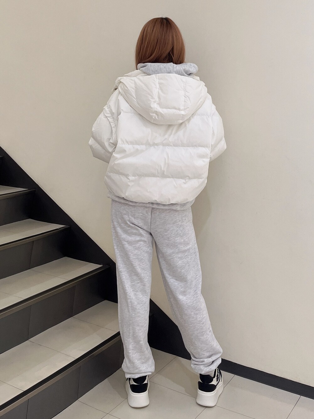 ホワイト系のダウンジャケット/コート、グレー系のパーカー、グレー系のスウェットパンツを着用したレディースの秋コーディネートの3枚目の写真