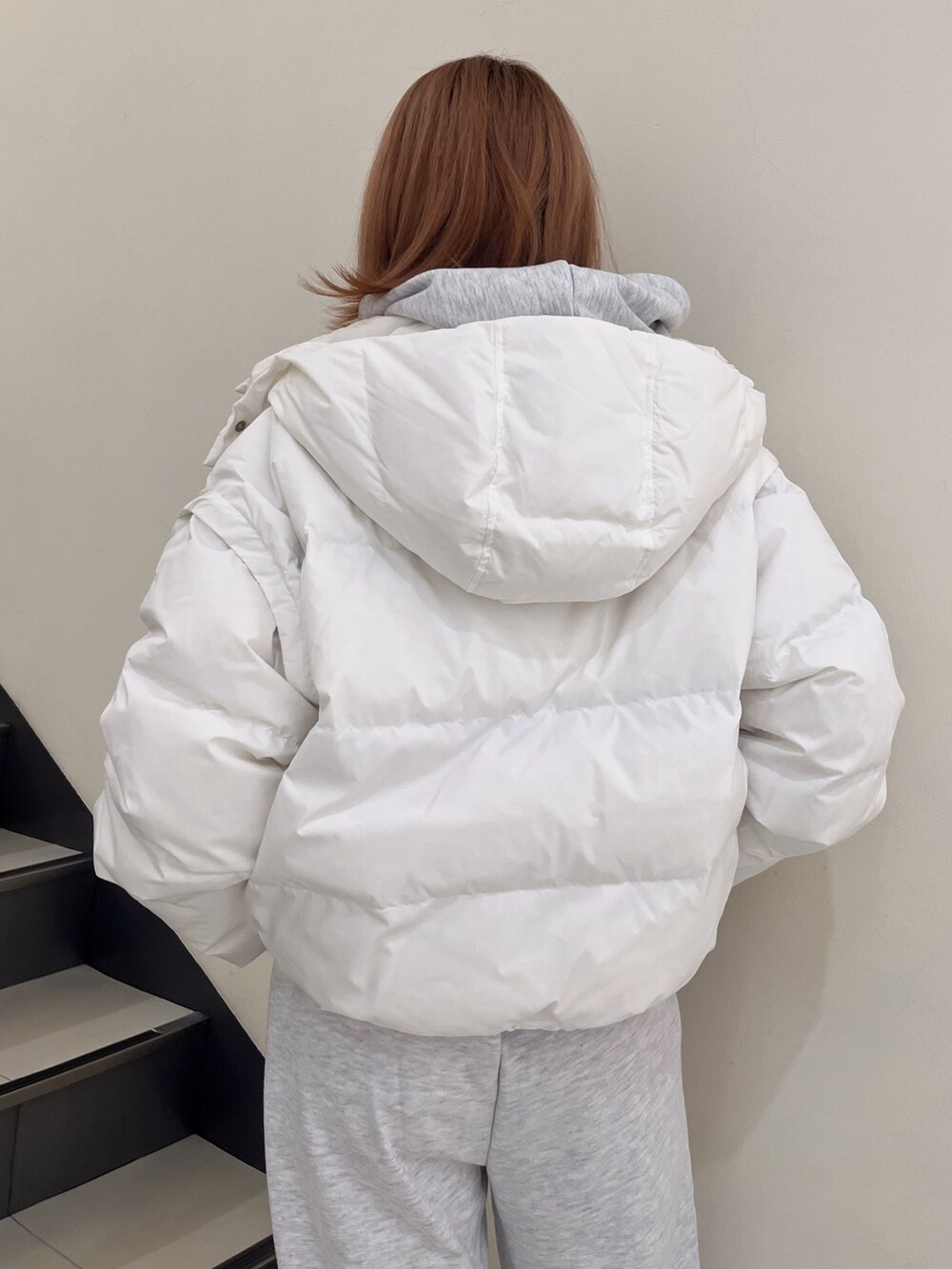 ホワイト系のダウンジャケット/コート、グレー系のパーカー、グレー系のスウェットパンツを着用したレディースの秋コーディネートの5枚目の写真