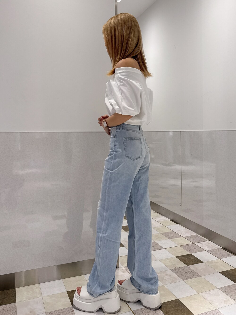 ホワイト系のTシャツ/カットソー、ブルー系のデニムパンツ、ホワイト系のサンダルを着用したレディースの春コーディネートの2枚目の写真