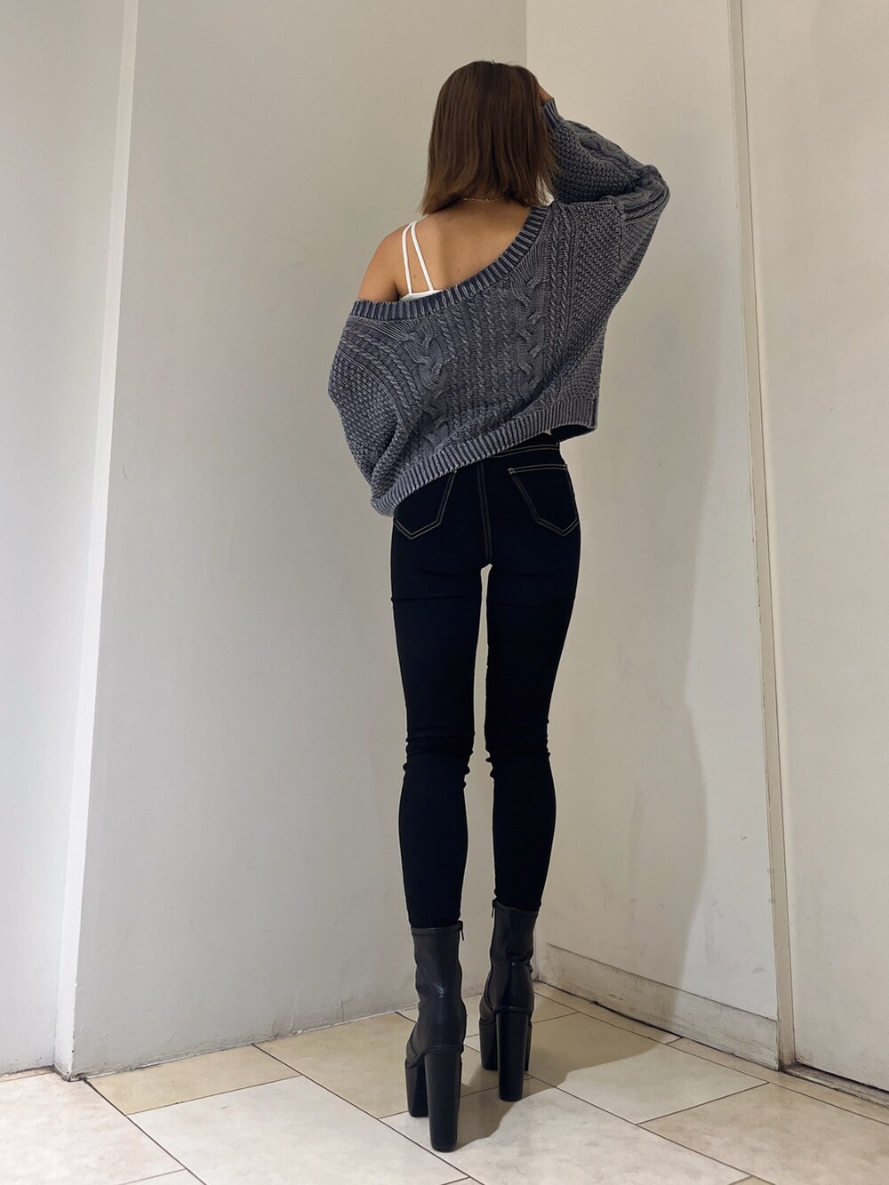 ブルー系のニット/セーター、ホワイト系のキャミソール、ブラック系のデニムパンツを着用したレディースの秋コーディネートの3枚目の写真