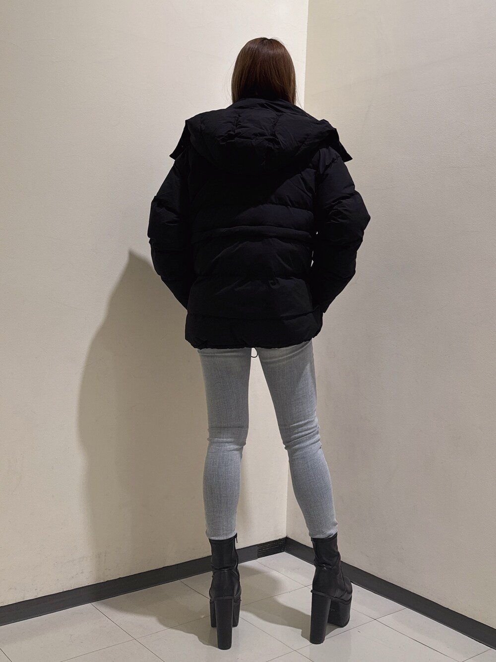 ブラック系のダウンジャケット/コート、グレー系のニット/セーター、ブルー系のデニムパンツを着用したレディースの冬コーディネートの3枚目の写真