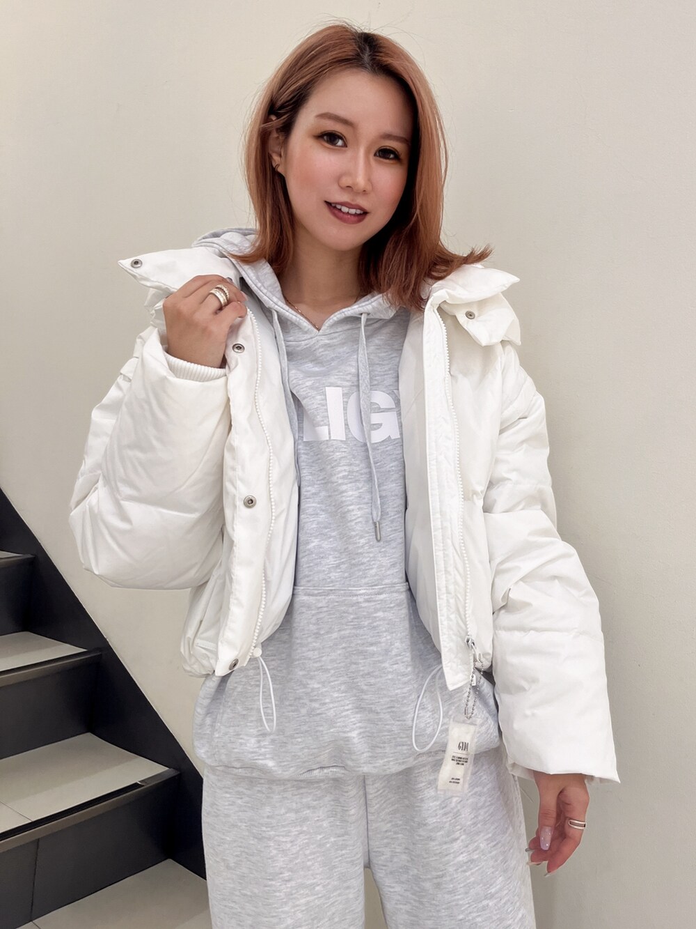 ホワイト系のダウンジャケット/コート、グレー系のパーカー、グレー系のスウェットパンツを着用したレディースの秋コーディネートの4枚目の写真