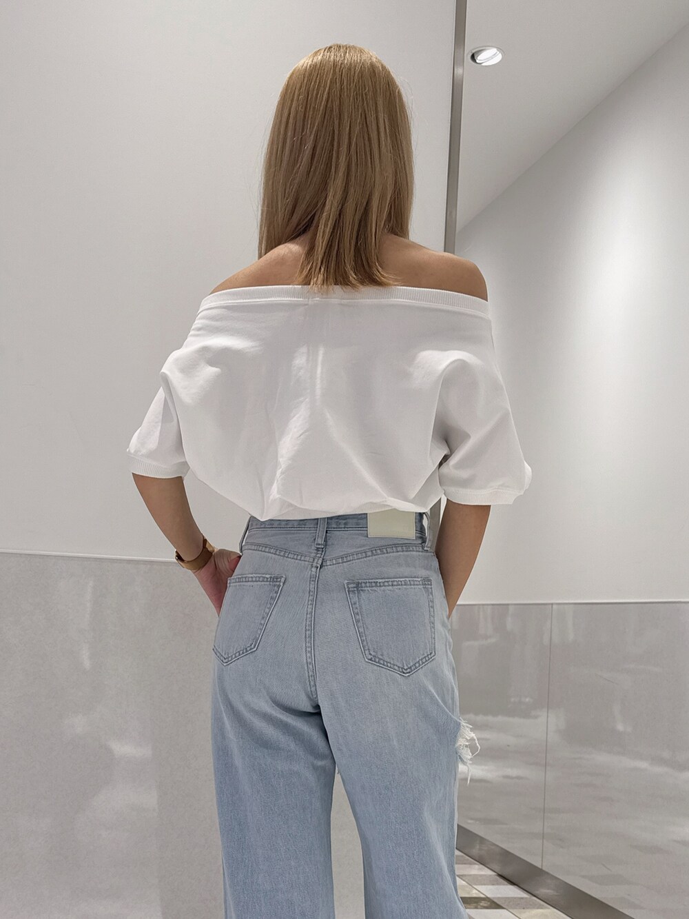 ホワイト系のTシャツ/カットソー、ブルー系のデニムパンツ、ホワイト系のサンダルを着用したレディースの春コーディネートの5枚目の写真