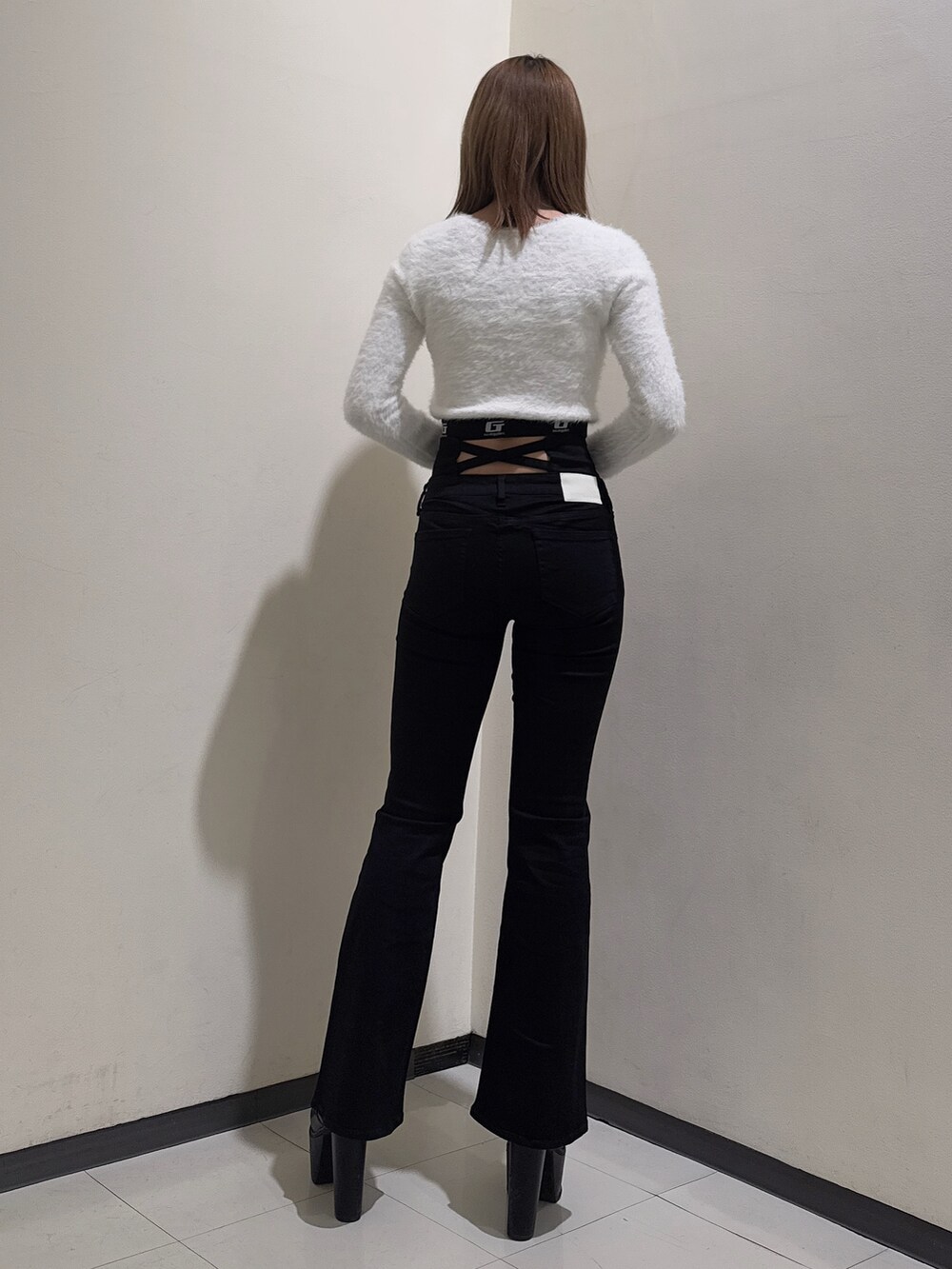 ホワイト系のニット/セーター、ブラック系のデニムパンツ、ブラック系のブーツを着用したレディースの冬コーディネートの3枚目の写真