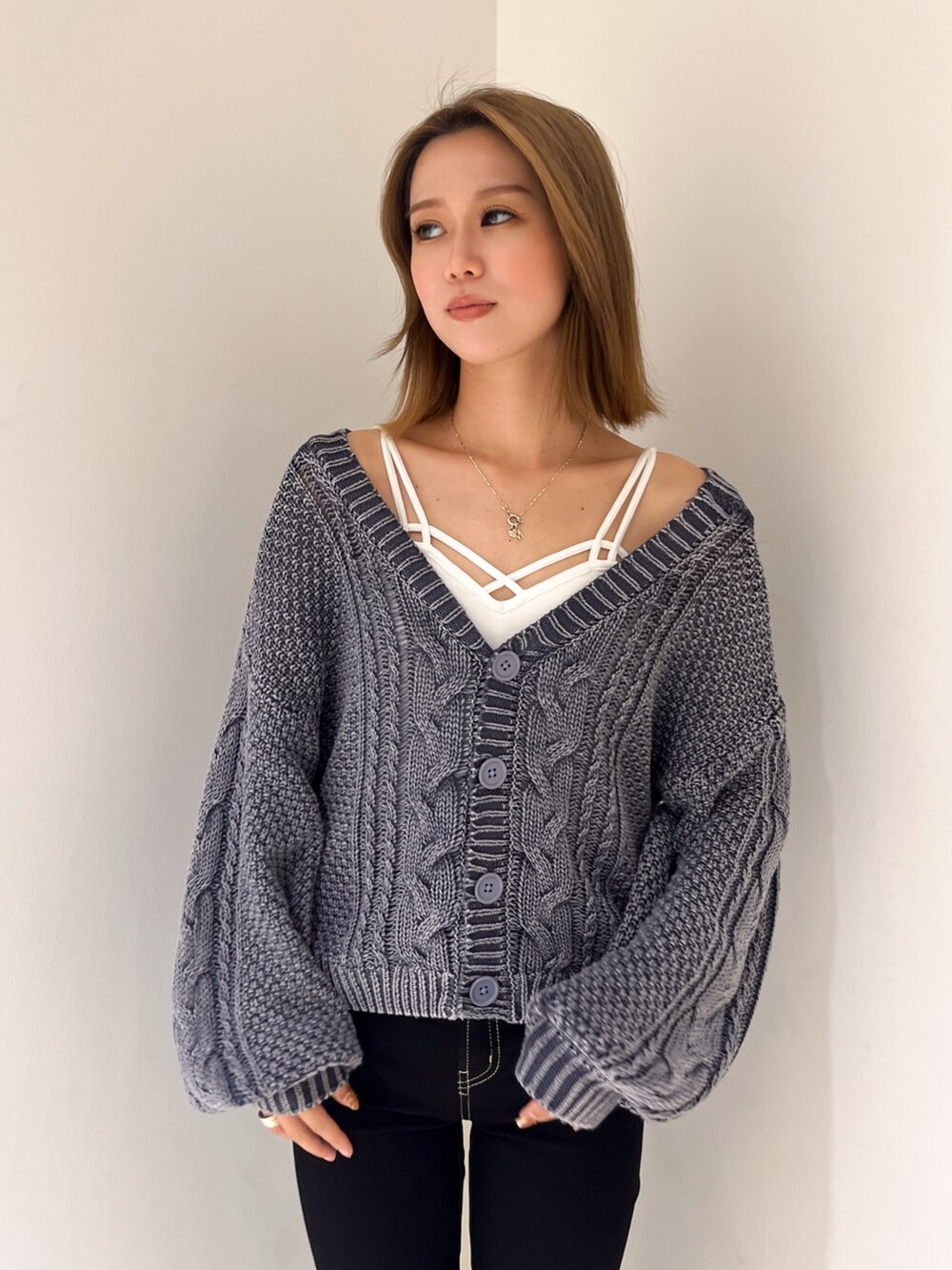 ブルー系のニット/セーター、ホワイト系のキャミソール、ブラック系のデニムパンツを着用したレディースの秋コーディネートの4枚目の写真