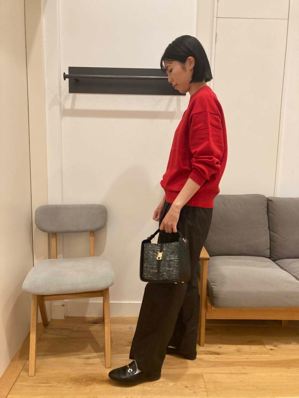 ブラック系のローファー、ブラック系のショルダーバッグ、レッド系のニット/セーターを着用したレディースの秋コーディネートの2枚目の写真