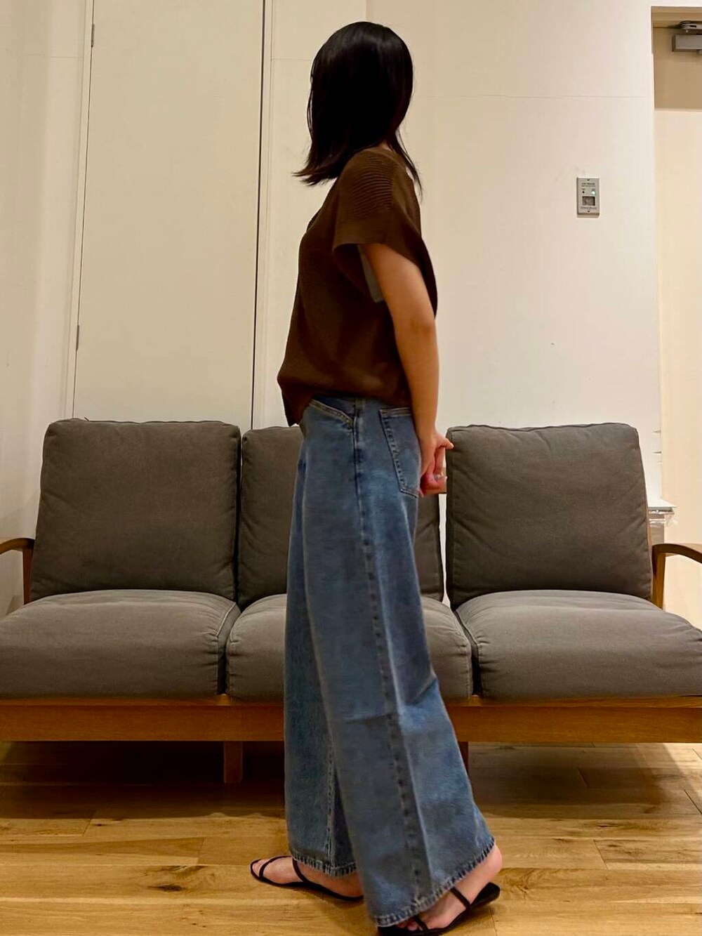 ホワイト系のタンクトップ、ブラウン系のベストを着用したレディースの夏コーディネートの2枚目の写真