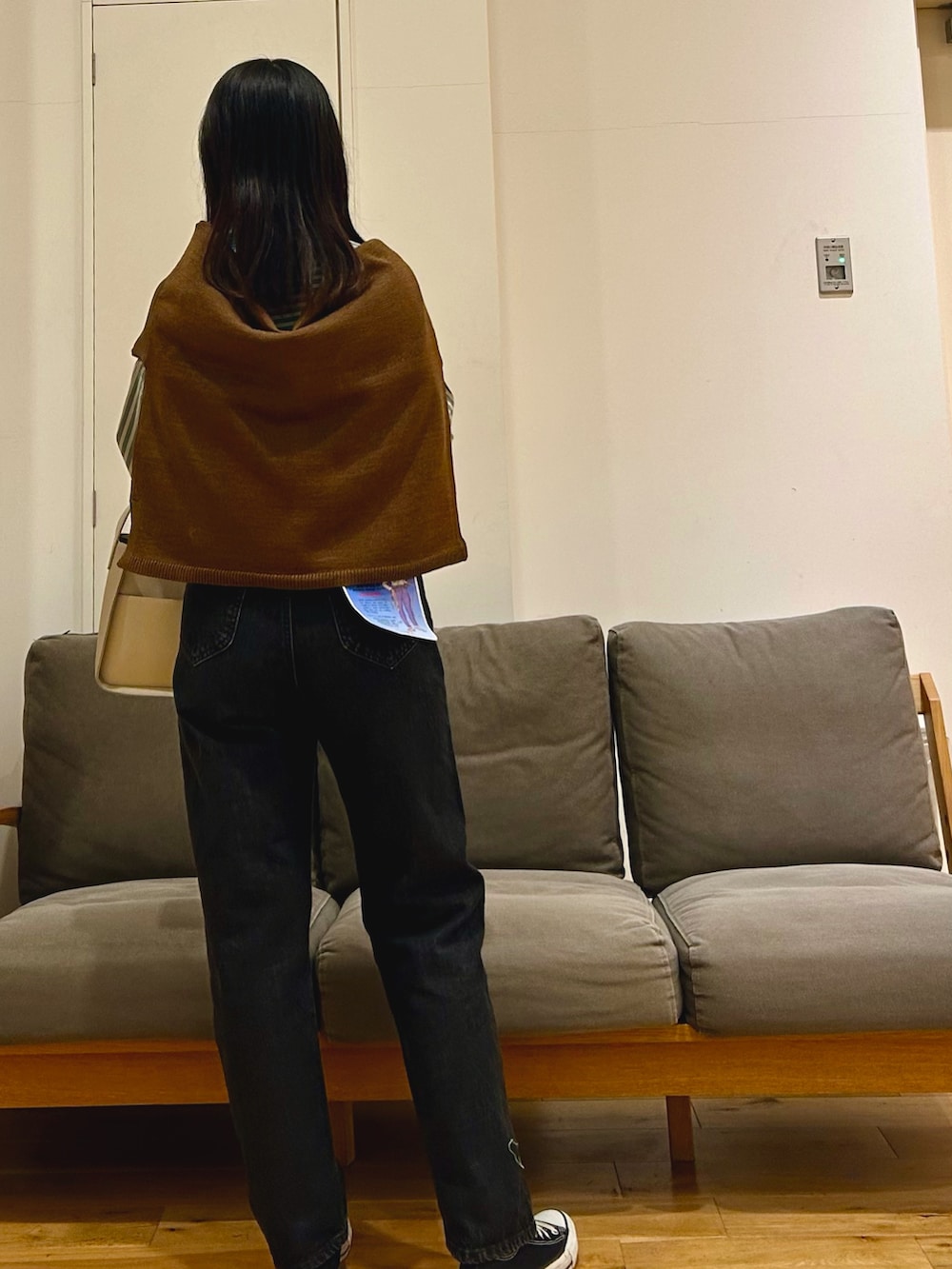 ブラウン系のカーディガン/ボレロ、ブラック系のデニムパンツ、グレー系のハンドバッグを着用したレディースの秋コーディネートの2枚目の写真