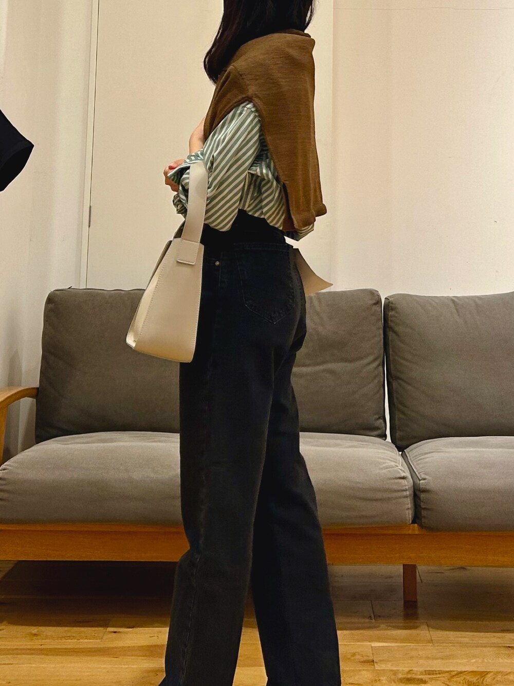 ブラウン系のカーディガン/ボレロ、ブラック系のデニムパンツ、グレー系のハンドバッグを着用したレディースの秋コーディネートの3枚目の写真